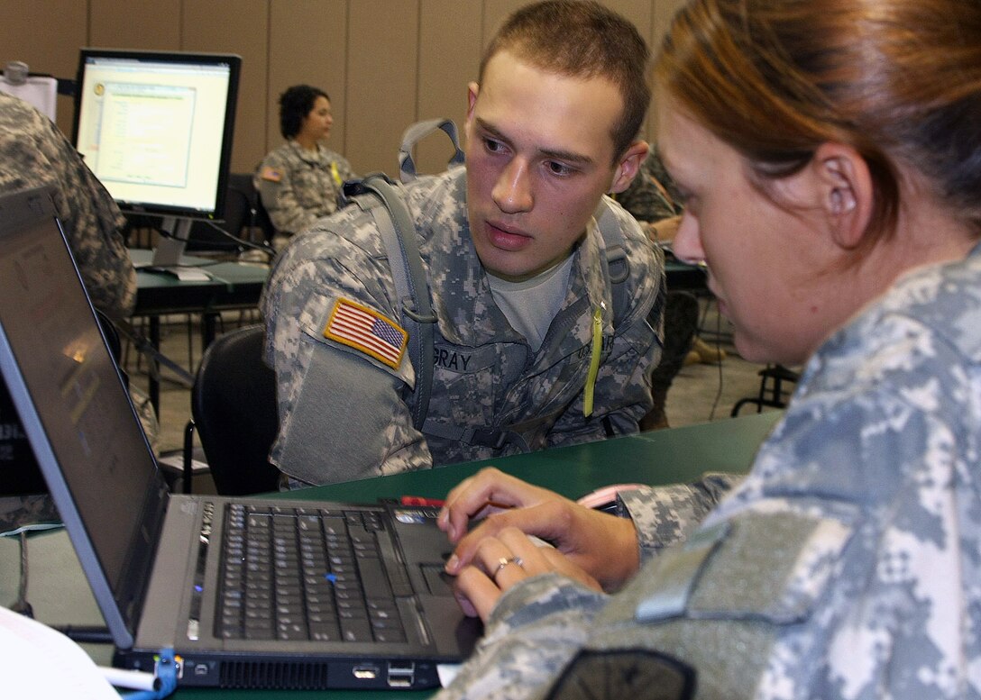 Pfc. Cory Gray and a military policeman with the 381th Military Police Company, 81st Troop Command, Indiana Army National Guard, review records during soldier readiness processing at Camp Atterbury, Ind., June 17, 2010. Soldiers of the 381st, 384th and 387th Military Police Companies along with the 215th Area Support Medical Company are currently training at Camp Atterbury in preparation for an upcoming humanitarian aid mission in Haiti.
