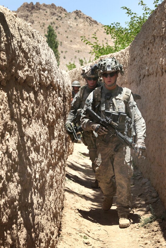 A U.S. Army cavalrymen and Afghan National Army soldier travel a trail between qalat walls while on patrol into the village of Qalirais, in Charkh Valley, Logar province, Afghanistan, June 19, 2010.