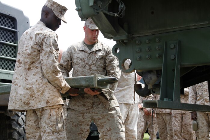 Lance Cpl. Keenen Chapple-Brown, a Marine Wing Support Squadron 171 logistics vehicle systems operator, and Pvt. Zachary Leininger, an MWSS-171 motor vehicle operator, work together to hook up two vehicles together during a professional military education class, which was taught during Exercise Thunder Horse at Penny Lake field here June 23. Exercise Thunder Horse was conducted to train MWSS-171 Marines in motor transport operations and prepare them for the upcoming exercise Haramura slated for July 16-23 in Haramura, Japan.
