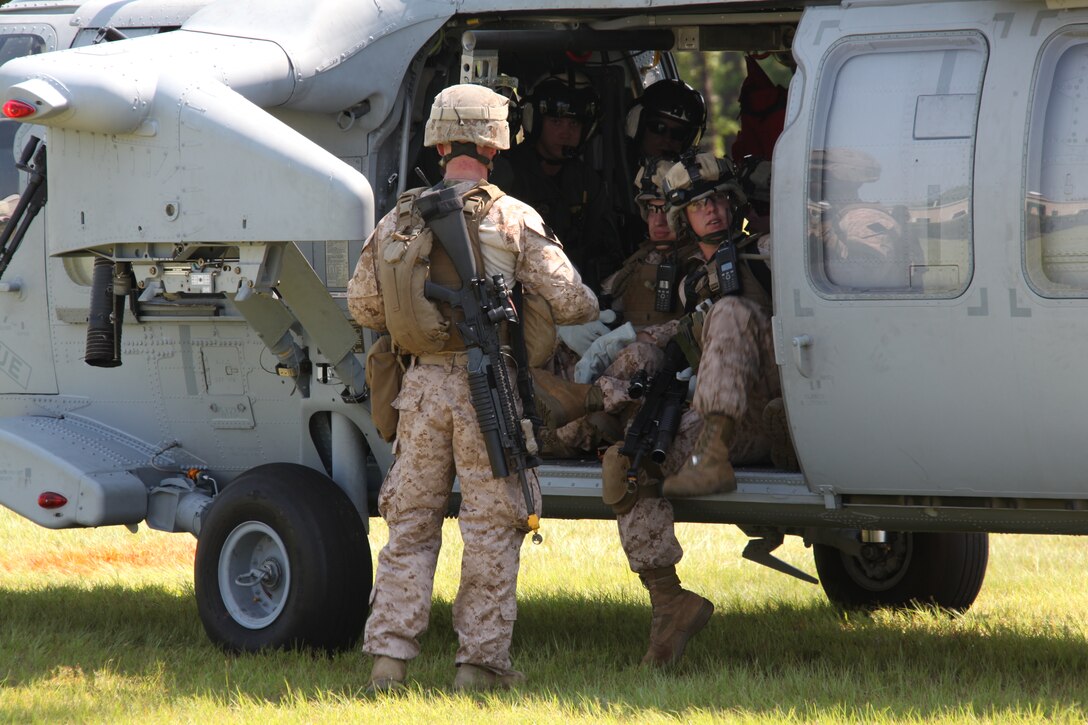 Marines with 26th Marine Expeditionary Unit settle into a MH-60S Seahawk with Helicopter Sea Combat Squadron 22 prior to conducting a maritime interception operations exercise at a training facility in Barnwell, S.C., June 23, 2010. 26th MEU Unit’s Maritime Interception Operation raid force and HSC-22 conducted the three-day exercise in preparation for deployment  this fall. The exercise hones the MEU’s ability to swiftly control the operation of a hostile ship or maritime platform. (Official USMC Photo by Lance Cpl. Santiago G. Colon Jr.)::r::::n::