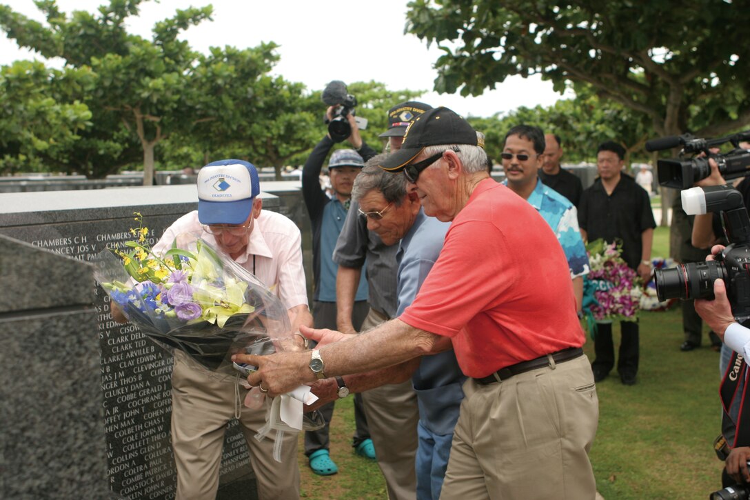 American veterans of the Battle of Okinawa lay a wreath before a portion of the 'Cornerstone of Peace' memorial inscribed with the names of fallen U.S. service members. Okinawa Peace Memorial Park is made up of sections of these memorials commemorating the lives of those who died during the battle of Okinawa in World War II.