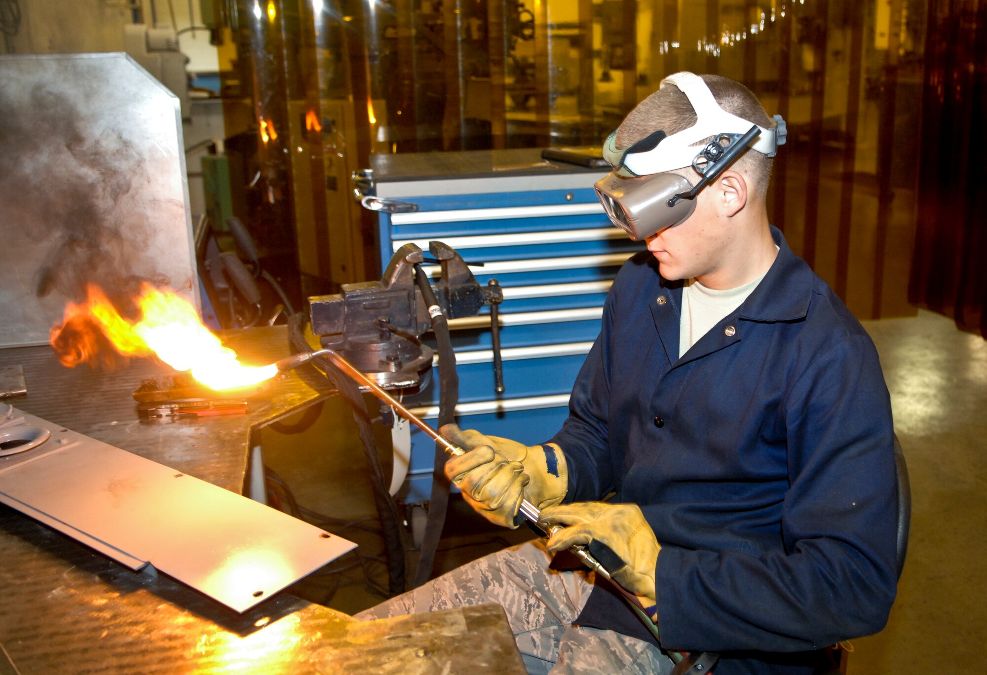 Airman 1st Class Derek Johnson, 3rd Equipment Maintenance Squadron, ignites his torch to begin the process of repairing some air-ground equipment, June 22. The metals technologies shop is responsible for many repair and maintenance jobs on Elmendorf. (Air Force photo by Airman 1st Class Jack Sanders)