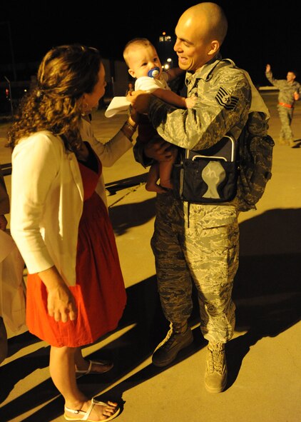 DYESS AIR FORCE BASE, Texas—Tech. Sgt. Tomio Brown, 39th Airlift Squadron, reunites with his wife Amie and son T.J. here June 23 after returning from a six-month deployment supporting Overseas Contingencies Operations. Over 180 Airmen from the 317th Airlift Group, 7th Component Maintenance Squadron and 7th Logistics Readiness Squadron were greeted by family members, co-workers and friends. (U.S. Air Force photo/ Airman 1st Class Brittney Smolinski)