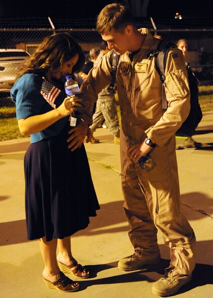 DYESS AIR FORCE BASE, Texas—Capt. Gordon White, 39th Airlift Squadron, caresses the belly of his expecting wife Catherine here June 23 after returning from a six-month deployment supporting Overseas Contingencies Operations. Over 180 Airmen from the 317th Airlift Group, 7th Component Maintenance Squadron and 7th Logistics Readiness Squadron were greeted by family members, co-workers and friends. (U.S. Air Force photo/ Airman 1st Class Brittney Smolinski)