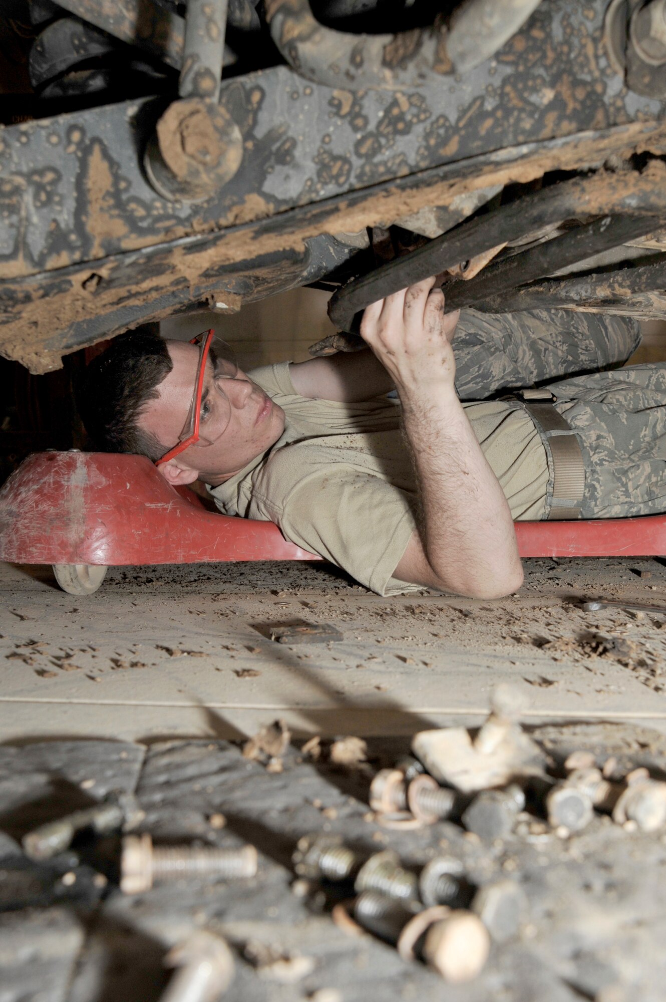 Airman 1st Class Ryan Slifko removes a brake caliper to install new brake pads on a Humvee June 19, 2010, at Sather Air Base, Iraq. Airman Slifko joined the Air Force, went into the same career field, and deployed to the same unit as his father, Senior Master Sgt. CJ Slifko. Airman Slifko is a vehicle mechanic with the 447th Expeditionary Logistics Readiness Squadron. Sergeant Slifko is the vehicle fleet manager for the 447th ELRS. (U.S. Air Force photo/Senior Airman Perry Aston)