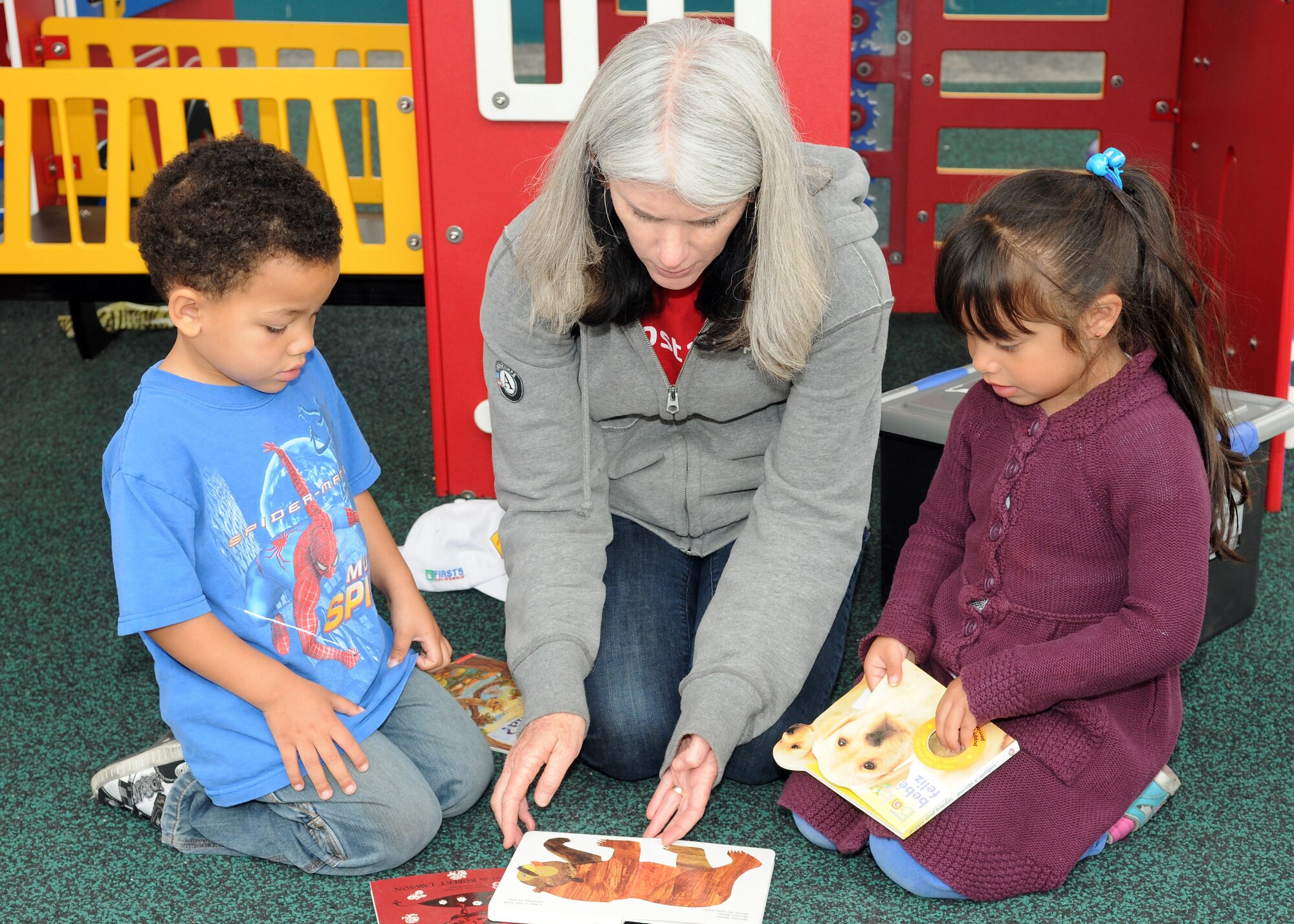 A volunteer from the 61st Communications Squadron reads to children at the Inglewood Child Development Center, June 22.  The center is run by the Inglewood Unified School District and provides programs for preschoolers, ages 3 to 5. (Photo by Jim Gordon)