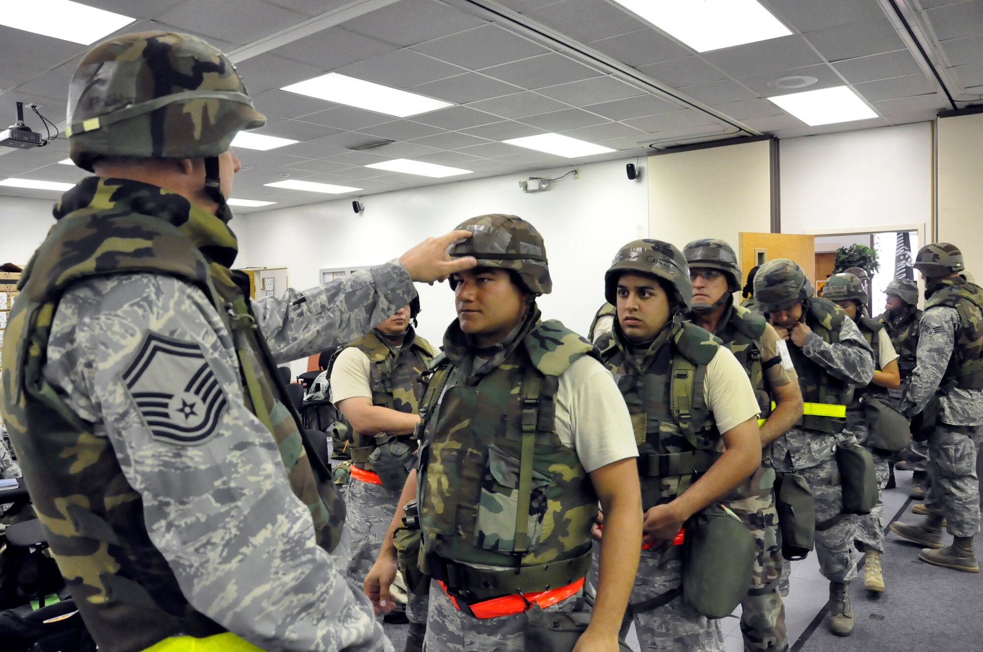 Senior Master Sgt. George Welch, 70th Aerial Port Squadron, inspects Senior Airman Andres Silvera's equipment while other members of the ORI team await inspection on May 14. The 70th APS recently recieved an "excellent" rating during their Operational Readiness Inspection in Gulfport, Miss. (U.S. Air Force photo/Tech. Sgt. Robert Gibson)