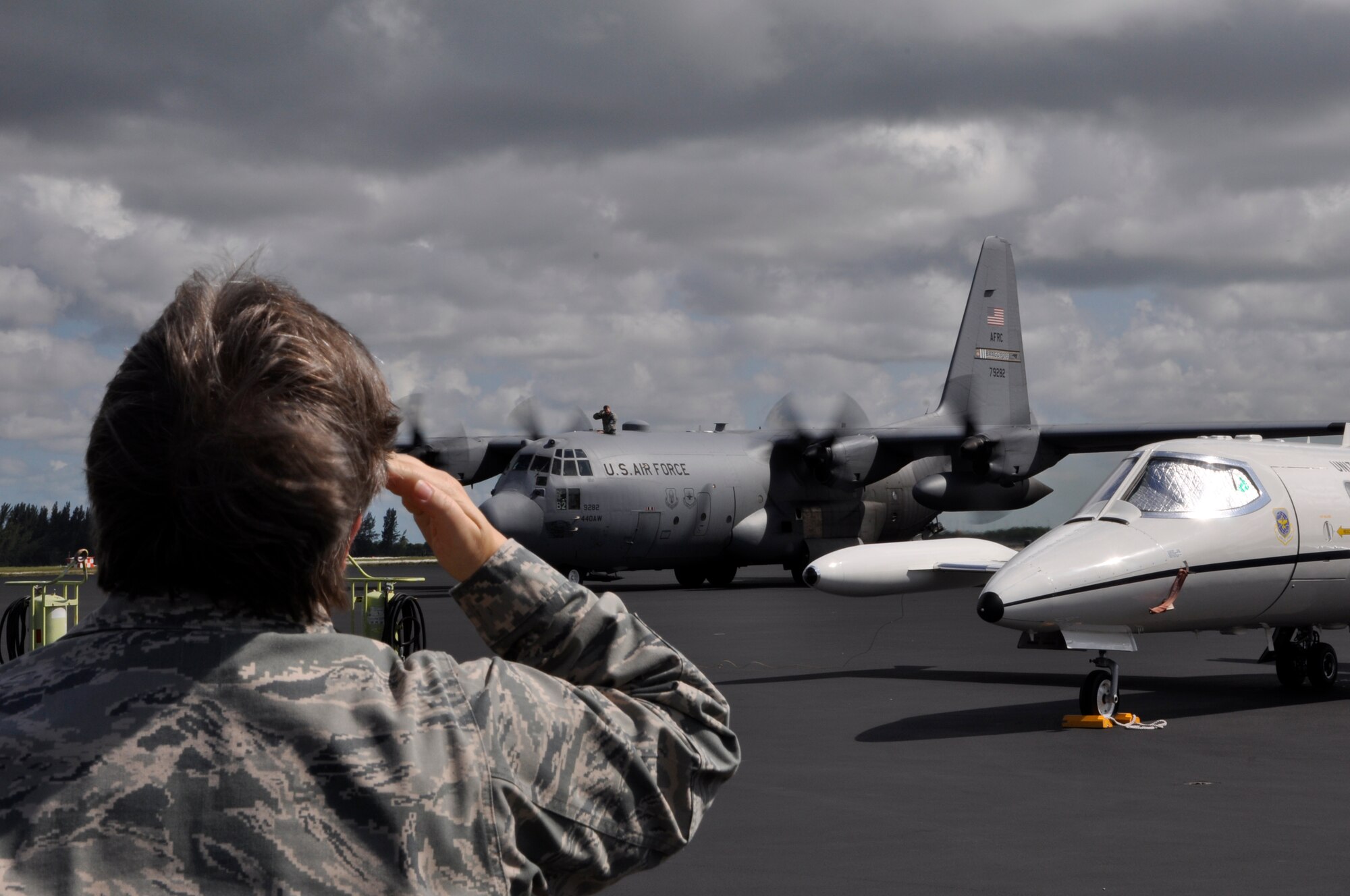 Lt. Col. Diana Echols, 70th Aerial Port Squadron commander salutes Capt. John Weeks atop a C-130 after the Reservists returned from Gulfport, Miss. The 70th APS team members recieved an excellent rating on their recent Operational Readiness Inspection. (U.S. Air Force photo/Tech. Sgt. Robert Gibson)