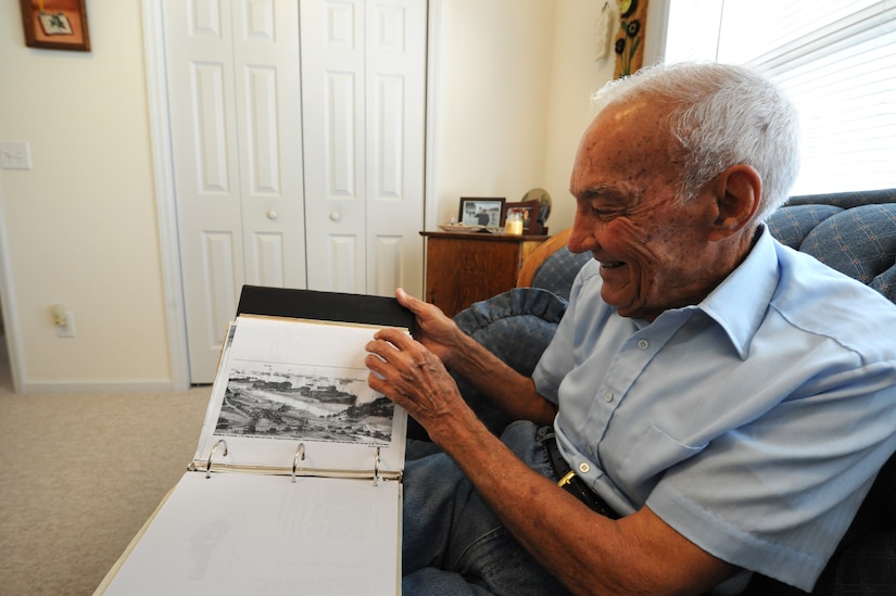 Mr. Reid Cayce flips through pages of World War II photos from Normandy at his home in Summerville, S.C., June 15, 2010. In the morning hours of June 6, 1944, known as D-Day, Mr. Cayce's amphibious vehicle was part of a 5,000 vessel  armada that sailed across the English Channel to Normandy. More than 150,000 men and nearly 30,000 vehicles crossed the channel to begin the invasion of France. (U.S. Air Force photo/James M. Bowman)