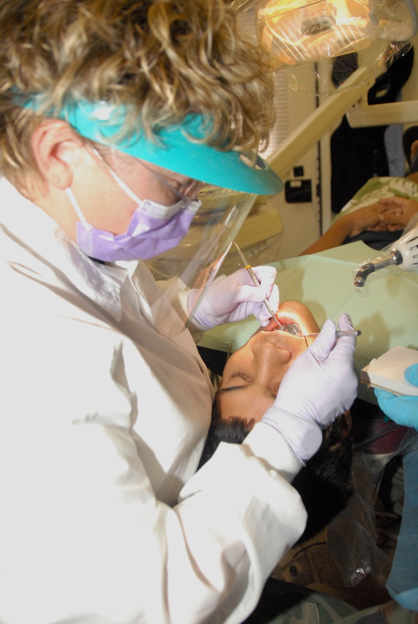 Maj. (Dr.) Suzanne Maslo, the dental flight commander for the 911th Aeromedical Staging Squadron, Pittsburgh Air Reserve Station, works on a patient June 15 at Ocean View Community Center, Hawaii. Doctor Maslo is attached to the 178th Fighter Wing, Ohio Air National Guard, for a two-week training deployment in which the unit provides free medical services to communities June 7 – 17 in Kona, Hawaii.  