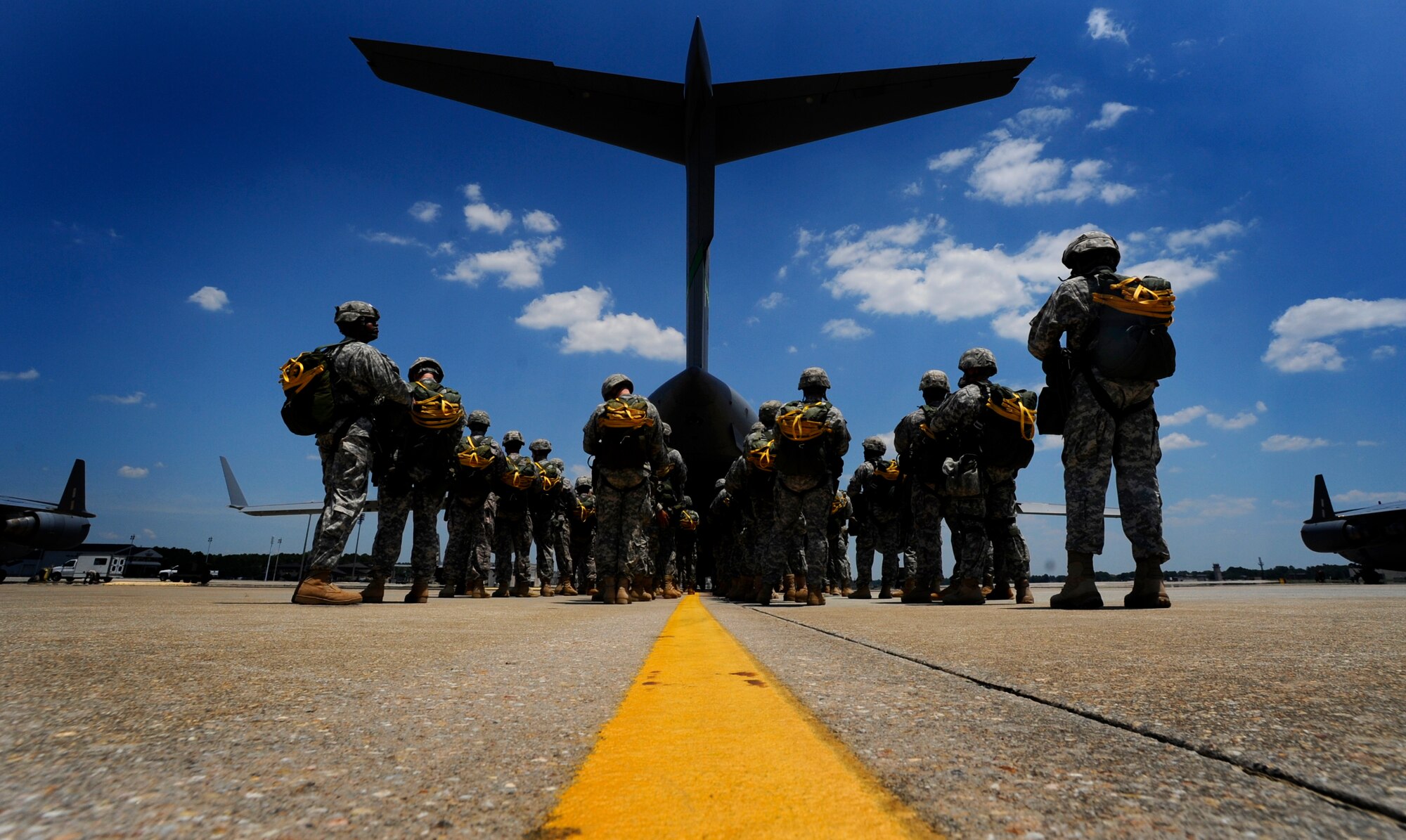 The tail of a Charleston C-17 fills the sky as U.S. Soldiers wait to board on the flightline at Pope Air Force Base, N.C., during a joint forcible entry exercise June 21, 2010. More than 98 service members performed an airborne insertion from the C-17 during the JFEX. JFEX, which is a week-long exercise conducted six times a year by Soldiers from Fort Bragg and Airmen from Pope AFB and Joint Base Charleston, is designed to enhance cohesion between the Army and Air Force through large-scale heavy equipment and troop movements. (U.S. Air Force photo by Staff Sgt. Angelita M. Lawrence/Released)
