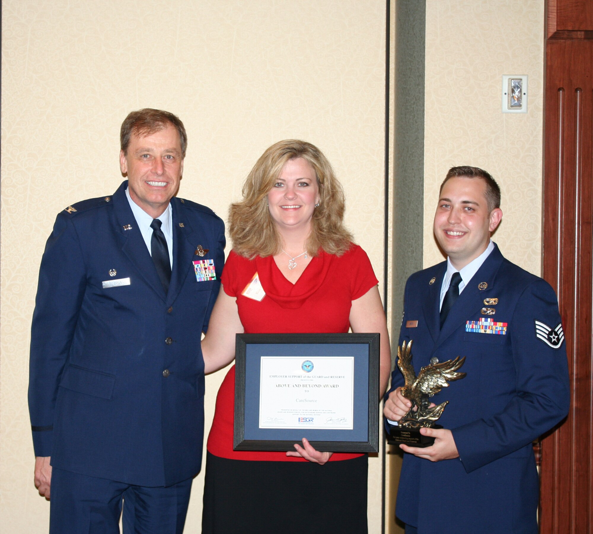 WRIGHT-PATTERSON AIR FORCE BASE, Ohio - Col.  Stephen Goeman, 445th Airlift Wing commander, congratulates Kim Gibson of CareSource, the employer of Staff Sgt. Patrick Smith, 87th Aerial Port Squadron (far right) at the Ohio Committee for ESGR Annual Employer Recognition Dinner June 5.  CareSource was recognized for its support of Staff Sgt. Smith. (U.S. Air Force photo/Maj. Cynthia Harris)