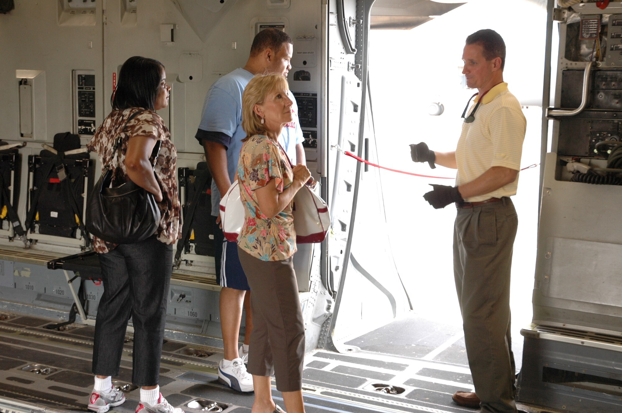 Ken Hundermer, loadmaster with the 317th Airlift Squadron, Charleston Air Force Base S.C. and manager of the Denton Humanitarian Assistance Program here, leads members from U.S. Transcom and the U.S. Defense Security Cooperation Agency on a tour of a C-17 June 23. The visitors were able to see a C-17 and the Aerial Port squadron on thier visit to gain a better understanding of the Denton program. (U.S. Air Force Photo/2nd Lt Joe Simms)