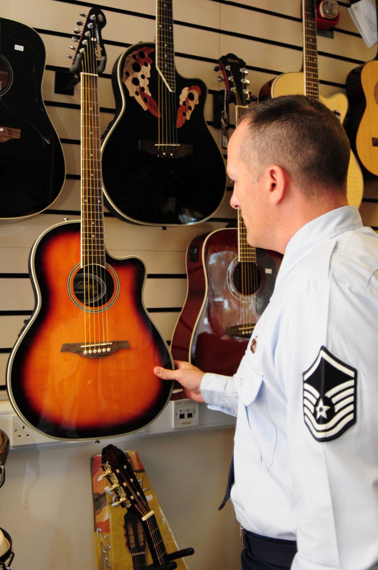 Master Sgt. Stephen Acker, 48th Operations Group Intelligence NCO in-charge of intelligence analysis, looks at the guitar selection at the Outdoor Recreation music store on RAF Lakenheath June 21. The music store provides various instruments as well as music books and different accessories to include amplifiers, tuners and cases. (U.S. Air Force photo/Airman 1st Class Lausanne Morgan)