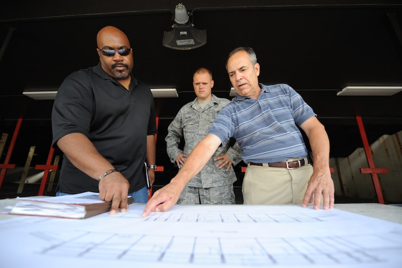 Darnell Edmonds, left, U.S. Air Force Staff Sgt. John Foster and Joe Rackley look at a profile view of a blue print of the improved weapons firing range on Joint Base Charleston, S.C., June 21, 2010. The  range was repaired due to safety deficiencies. The project started March 26 and was completed Base Wing deputy ground safety manager, Sergeant Foster is the NCO in charge of combat arms training and maintenance with the 628th Security Forces Squadron, and Mr. Rackley is Simplified Acquisition Base Engineering Requirements project manager. (U.S. Air Force photo/James M. Bowman)(released)