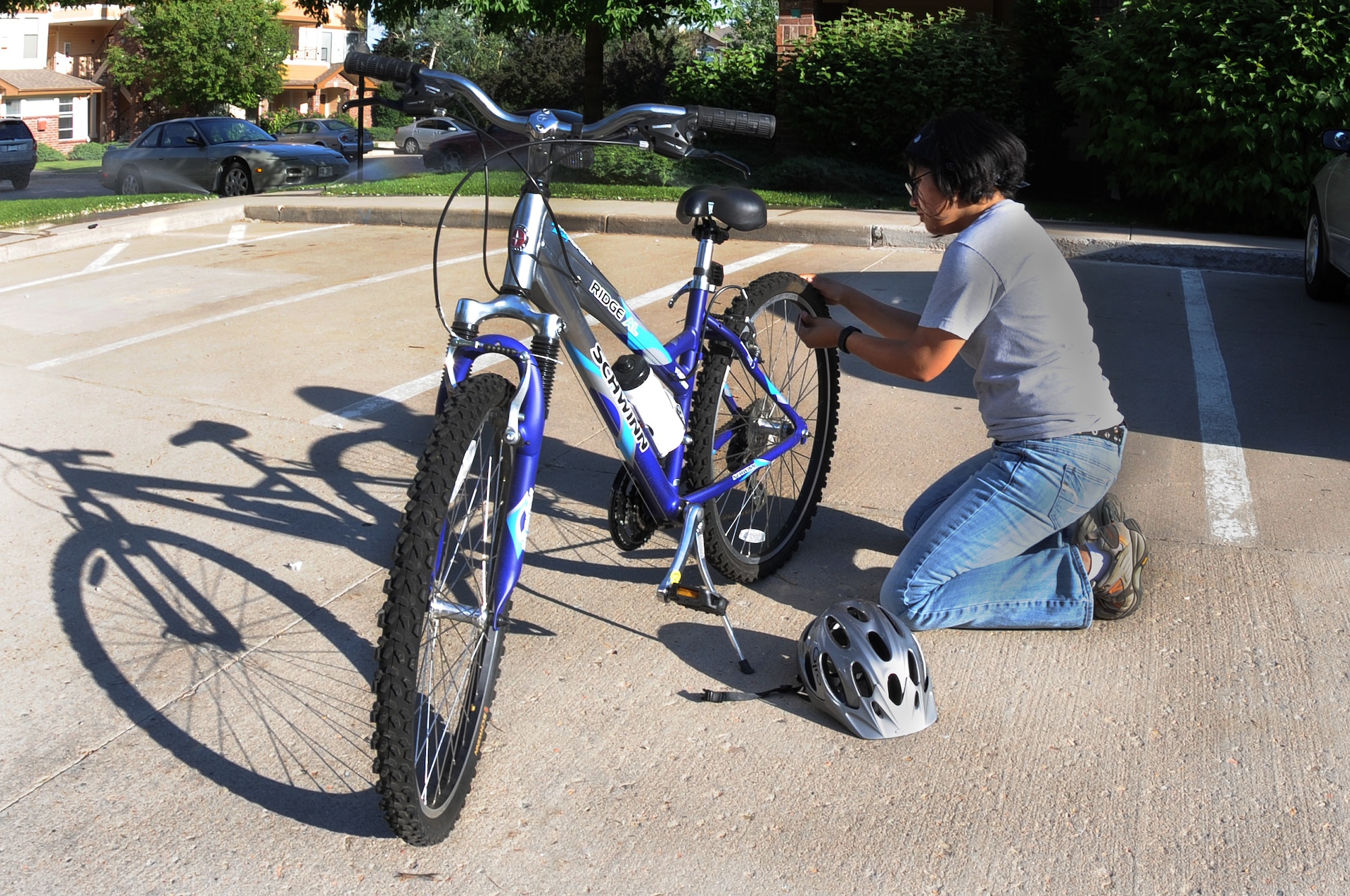 DENVER, Colo.-- Staff Sgt. Kathrine McDowell practices good safety procedures by checking her tires before riding her bicycle June 22. Sergeant McDowell keeps herself protected and uses all the right safety tips. (U.S. Air Force Photo by Airman 1st Class Manisha Vasquez)
