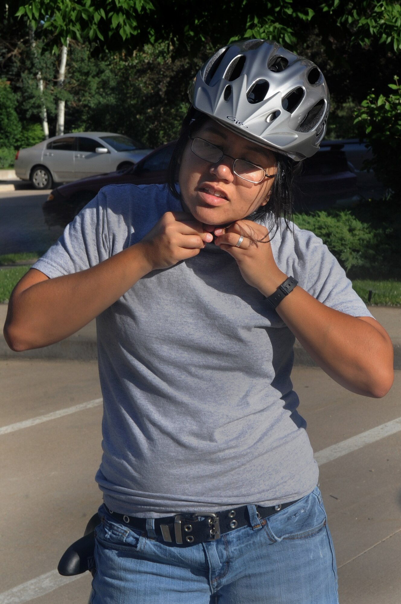 DENVER, Colo. -- Staff Sgt. Kathrine McDowell gears up to ride her bicycle by protecting herself and putting on her helmet June 22. Sergeant McDowell uses a helmet every time she rides a bike. (U.S. Air Force Photo by Airman 1st Class Manisha Vasquez) 