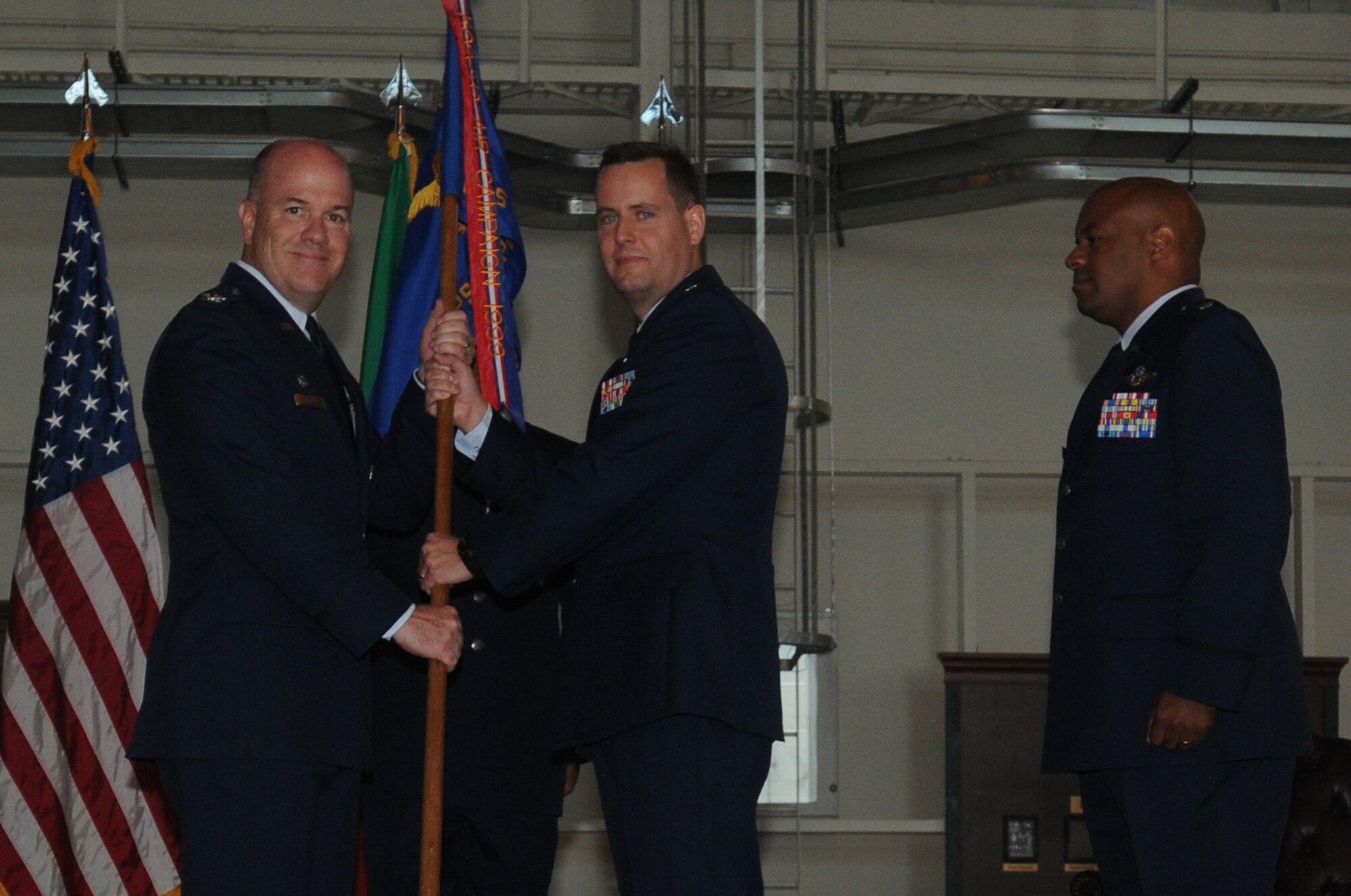 Lt. Col. Sean DeWitt (middle) passes the flag of the 31st Operations Support Squadron to Col. Patrick J.S. Miller, 31st Operations Group commander, as Lt. Col. Kenneth Smith 31st Fighter Wing safety officer looks on June 22 during the 31st OSS's change of command ceremony at Hangar 3.  Colonel DeWitt is the new deputy commander of the 31st OG.(U.S. Air Force photo/Airman LaVel Sterling)