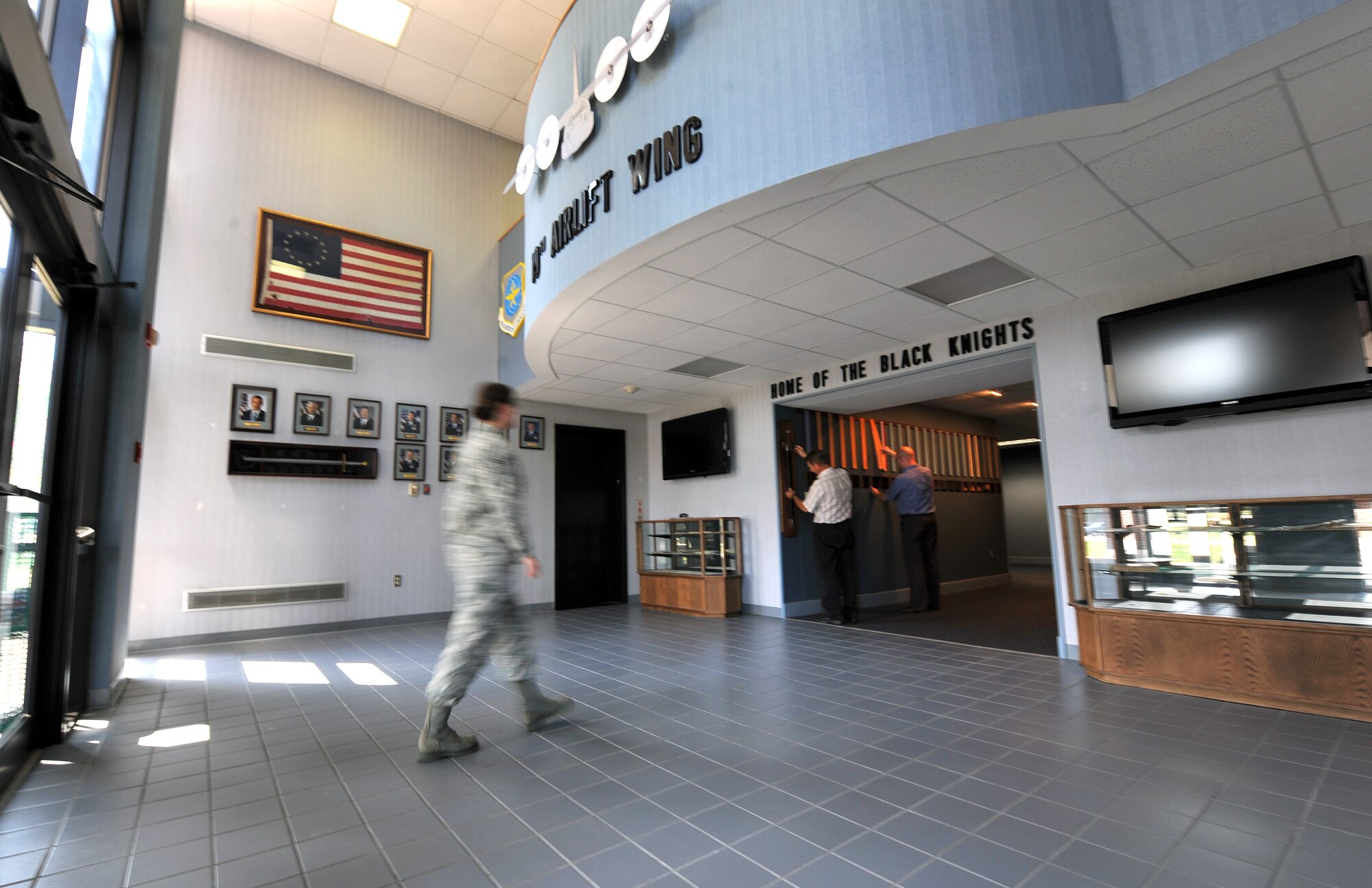 An Airman walks through the heritage hallway at the entrance of the 19th Airlift Wing headquarters building. Chris Hunkel, 19th Airlift Wing Public Affairs, said the hallway was assembled by a team of 19th Civil Engineer Squadron craftsmen to reflect the 19th Airlift Wing’s lineage (designated as either a group or wing) through its Army Air Forces and Air Force history. (U.S. Air Force photo by Senior Airman Chris Willis)