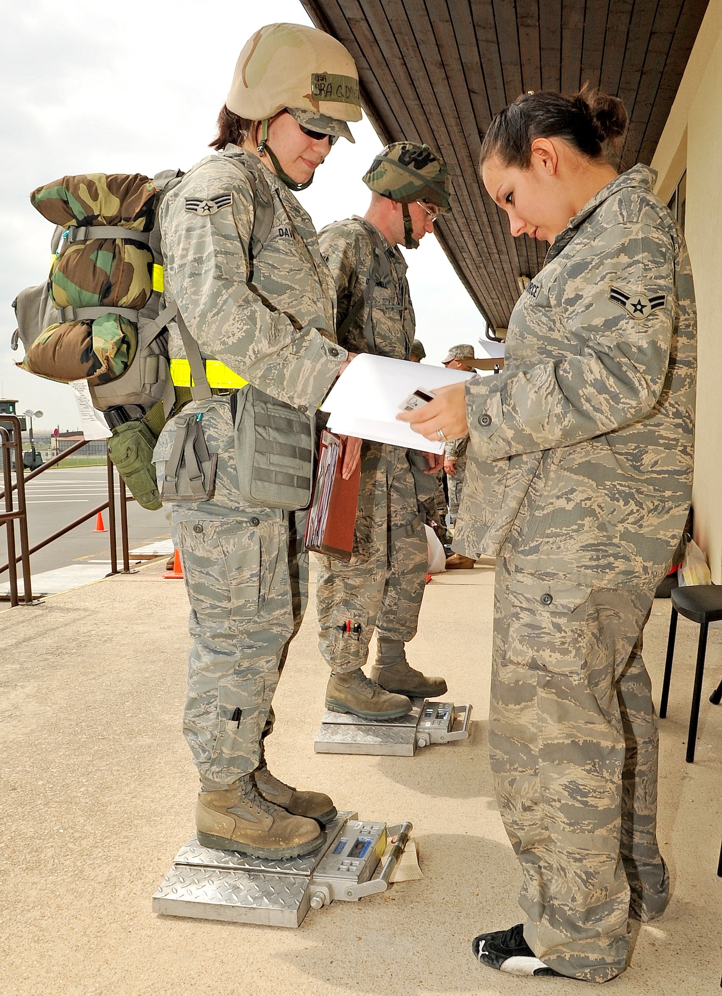 SPANGDAHLEM AIR BASE, Germany –From right to left, Airman 1st Class Lindsey Keidle, 52nd Logistics Readiness Squadron traffic management journeyman, weighs Senior Airman Grace David, 52nd Equipment Maintenance Squadron structural maintenance journeyman, to prepare an accountability list of Airmen for their troup commander that will travel on a simulated aircraft to their tactical area of responsibility before processing through a personnel deployment function during a Phase I Operational Readiness Inspection June 21. The PDF is part of a predeployment checklist Airmen must go through to ensure they have all the proper documentation, medical clearances and requirements to deploy. (U.S. Air Force photo/Airman 1st Class Nick Wilson)