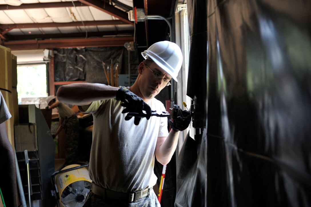 Senior Airman Brandon Long, 316th Civil Engineering Squadron electrician, re-routes a light switch in the Honor Guard building at Joint Base Andrews, Md.  June 22, 2010. The building is being renovated to give the base honor guard a place to practice ceremonial drill as well as give the 316 CES members a chance to train on more elaborate job skills. (U.S. Air Force photo by Staff Sgt. Renae Saylock)
