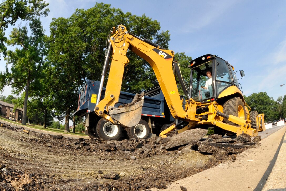 Mike Turpin, 316th Civil Engineering Squadron backhoe operator, removes old pavement on Arkansas road at Joint Base Andrews, Md.  June 22, 2010. The 316 CES is responsible for maintaining the base infrastructure to include all the facilities and roadways on the installations. (U.S. Air Force photo by Staff Sgt. Renae Saylock)