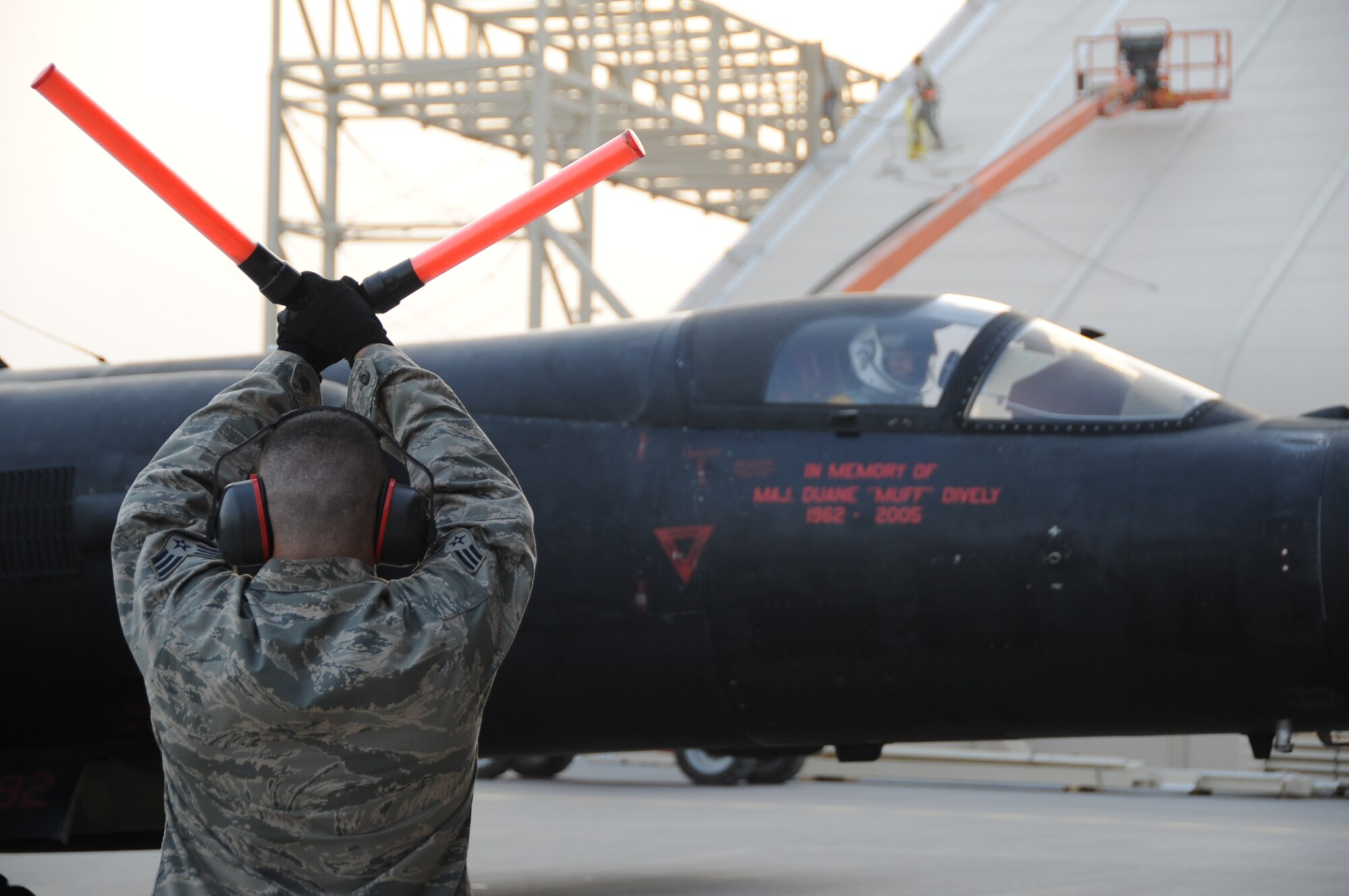 A 380th Air Expeditionary Wing maintainer marshals in a U-2 Dragon Lady after a memorial flight at a non-disclosed base in Southwest Asia June 22. The memorial flight was the fifth held in honor of Maj. Duane Dively, a U-2 pilot that lost his life in a combat mission. (U.S.  Air Force photo/ Tech. Sgt. April Wickes) 