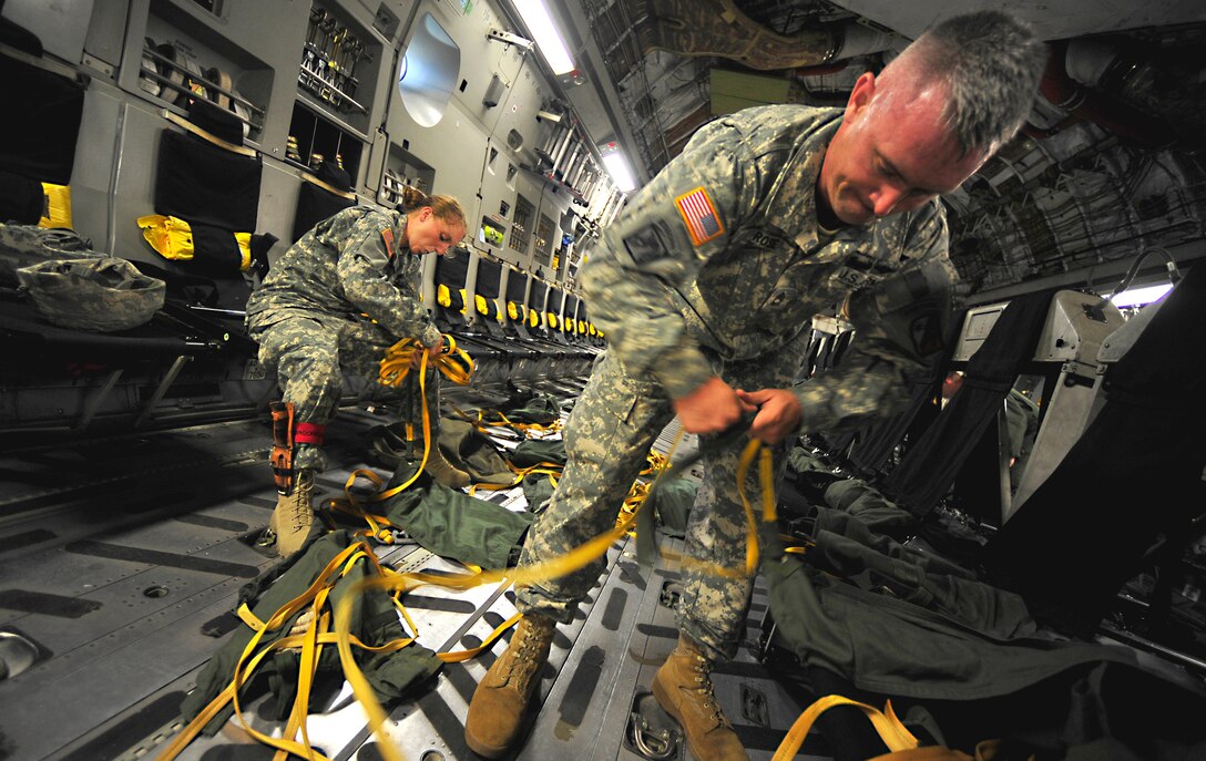 U.S. Army Staff Sgt. Jennifer Brockmoller, left, and Sgt. 1st Class Nicholas Rose, both with the 330th Movement Control Battalion, 647th Quartermaster Company, detangle parachute bags onboard a C-17 Globemaster III cargo aircraft after about 100 service members performed an airborne insertion during a joint forcible entry exercise June 21, 2010, at Pope Air Force Base , N.C. 
