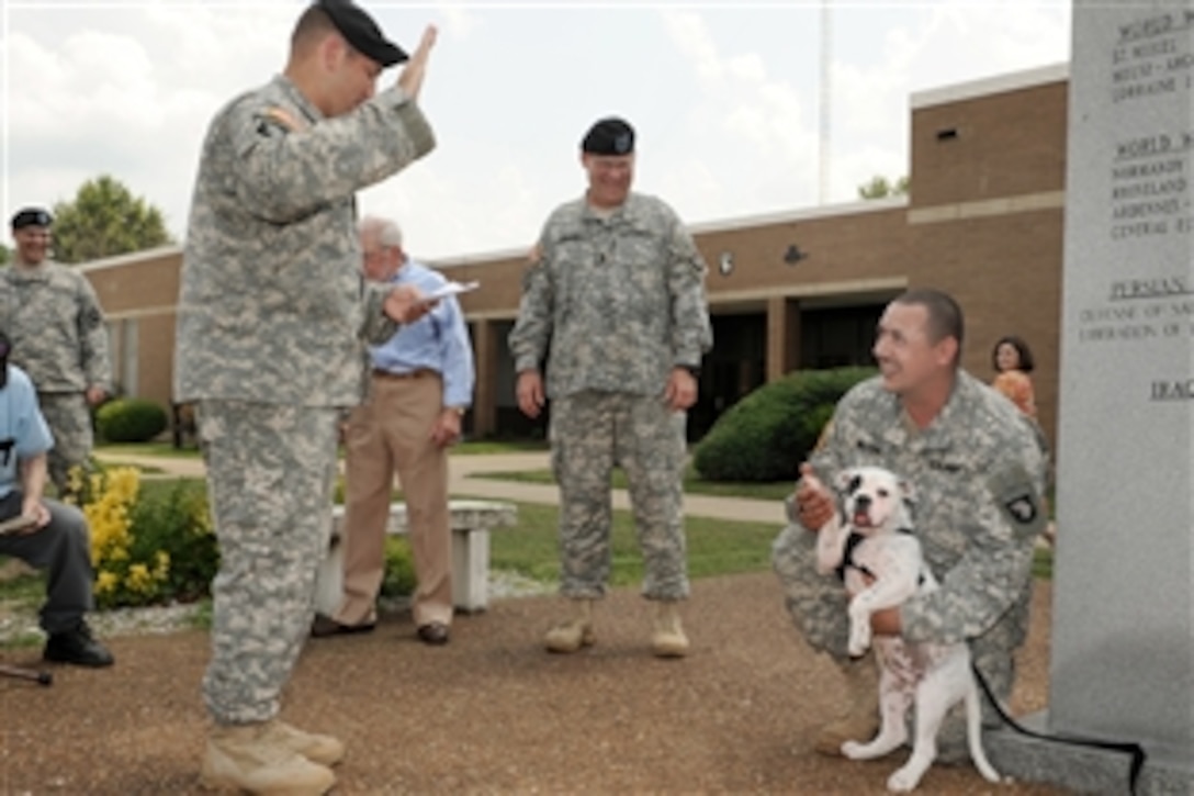 U.S. Army Maj. Jeff Kirby, left, gives the oath of enlistment to Bastogne VI, an English bulldog, during an induction ceremony for the mascot at Bastogne Field on Fort Campbell, Ky., June 18, 2010. Kirby, is 101st Airborne Division's commander of the rear detachment for the 1st Brigade Combat Team.