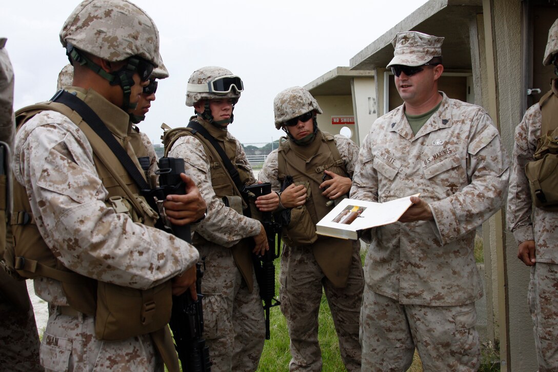 Sgt. Ryan Wilhite, a Marine Wing Support Squadron 171 explosive ordnance disposal assistant team leader, explains to MWSS-171 Marines how easily an improvised explosive device can be hidden between the pages of a book during an IED training course conducted at the north side dump here June 23. During the training, the participating Marines learned the components used to create IEDs, how they work and where they might be placed to kill them.