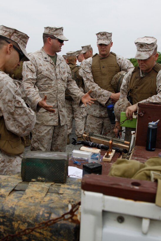 Sgt. Ryan Wilhite, a Marine Wing Support Squadron 171 explosive ordnance disposal assistant team leader, explains the workings of the different types of improvised explosive devices during an IED training course at the north side dump here June 23. The training was done to teach the Marines how to identify hidden IEDs on the road to reduce the number of service members falling victim to them.