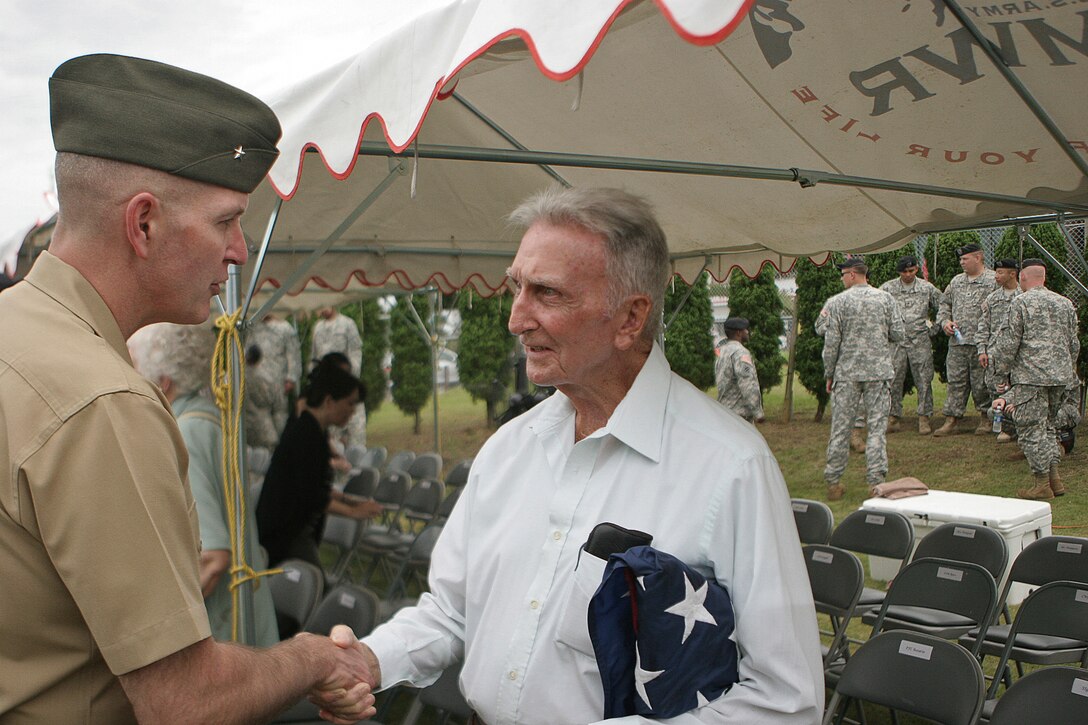 Brig. Gen. Mark A. Brilakis, the deputy commanding general, III Marine Expeditionary Force, and commanding general, III Marine Expeditionary Brigade, thanks retired Gunnery Sgt. Paul Moore for his service during an awards ceremony on Torii Station June 24.