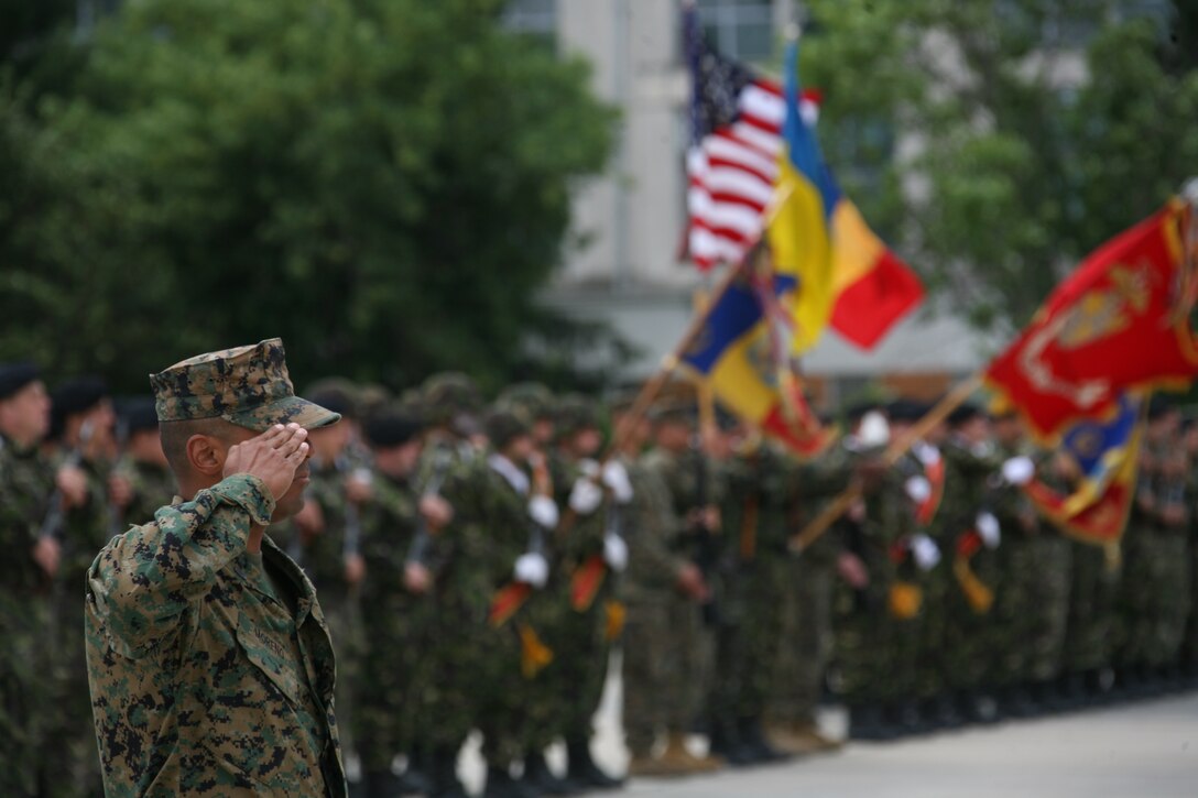 U.S. Marine Gunnery Sgt. Josiah Moreno salutes as the U.S., Ukrainian and Romanian national anthems play at the Black Sea Rotational Force closing ceremony at Mihail Kogalniceanu Airfield, Romania, June 24. Moreno, the nonlethal weapons training staff noncommissioned officer in charge for Black Sea Rotational Force, is part of a force of more than 100 Marines who deployed to Romania with the mission of promoting regional stability, bolstering partner nations’ military capabilities and building partnerships in the region.