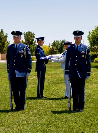 LAS VEGAS, Nev.-- Airman 1st Class Eric O'Neill assists Naval personnel with a funeral flag during the firing party sequence of a military funeral, at Palm Mortuary in Las Vegas, June 10, 2010. (U.S. Air Force Photo / Airman 1st Class Jamie Nicley)