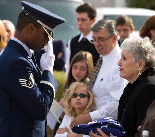 LAS VEGAS, Nev.-- US Air Force Staff Sgt. Julio Viloria salutes a funeral flag after handing it off to a widow during a performance of military funeral honors at Palm Mortuary in Las Vegas, March 18, 2010. (U.S. Air Force Photo / Airman 1st Class Jamie Nicley)