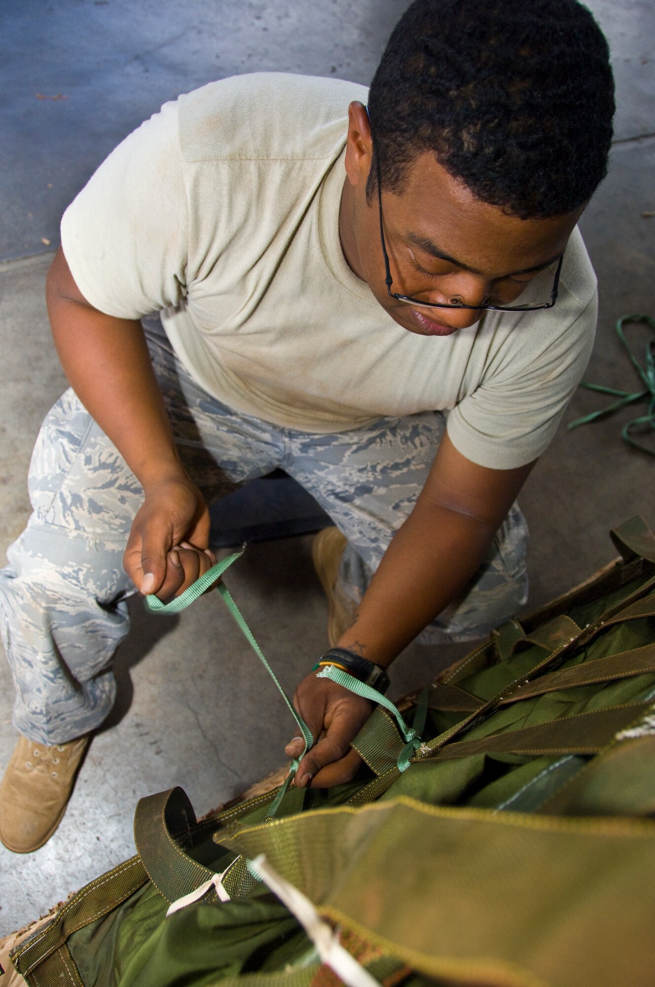 Staff Sgt. Dewayne Heidelberg , 647th Logistics Readiness Squadron air transportation specialist, secures a pallet with cord at Hangar 7 June 18. The cardboard was used in a pallet built to deliver  food through airdrop to Marines and Seabees on the island of Hawaii as part of the Rim of the Pacific exercise. (U.S. Air Force photo by Staff Sgt. Nathan Allen)