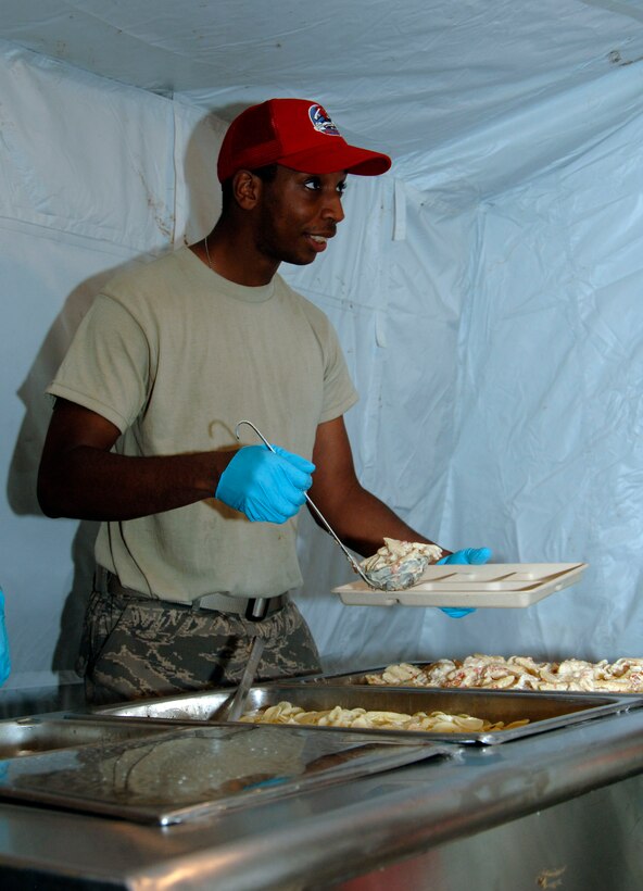 Airman 1st Class Mark Brown, 820th Expeditionary RED HORSE Squadron Services Airman, serves up the evening meal to a hungry worker June 23. Airman Brown is deployed in support of New Horizons Panama 2010 from the 87th Force Support Squadron, Joint Base McGuire-Dix-Lakehurst, N.J.  (U.S. Air Force photo/Tech. Sgt. Eric Petosky)