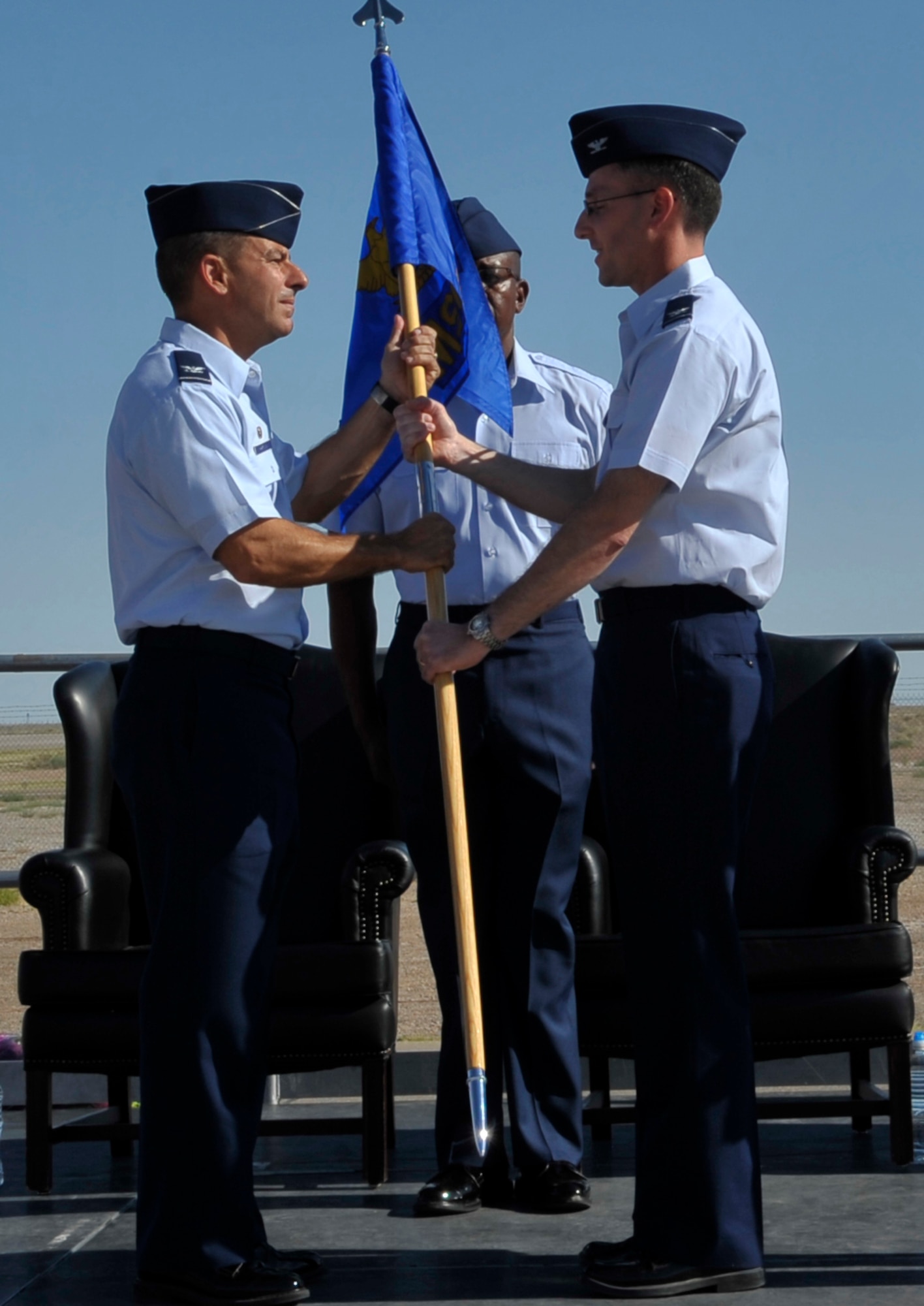 HOLLOMAN AIR FORCE BASE, N.M. -- Col. Jeff Harrigian, 49th Fighter Wing commander, accepts the guideon from Col. Stephen DiFonzo as he relinquishes command of the 49th Mission Support Group during a change of command ceremony June 21, 2010. The American change of command ceremony is a military tradition dating back to 1775. The banner was exchanged so every soldier could see the officer now entrusted to lead them into battle. (U.S. Air Force photo by Airman 1st Class Joshua Turner / Released)