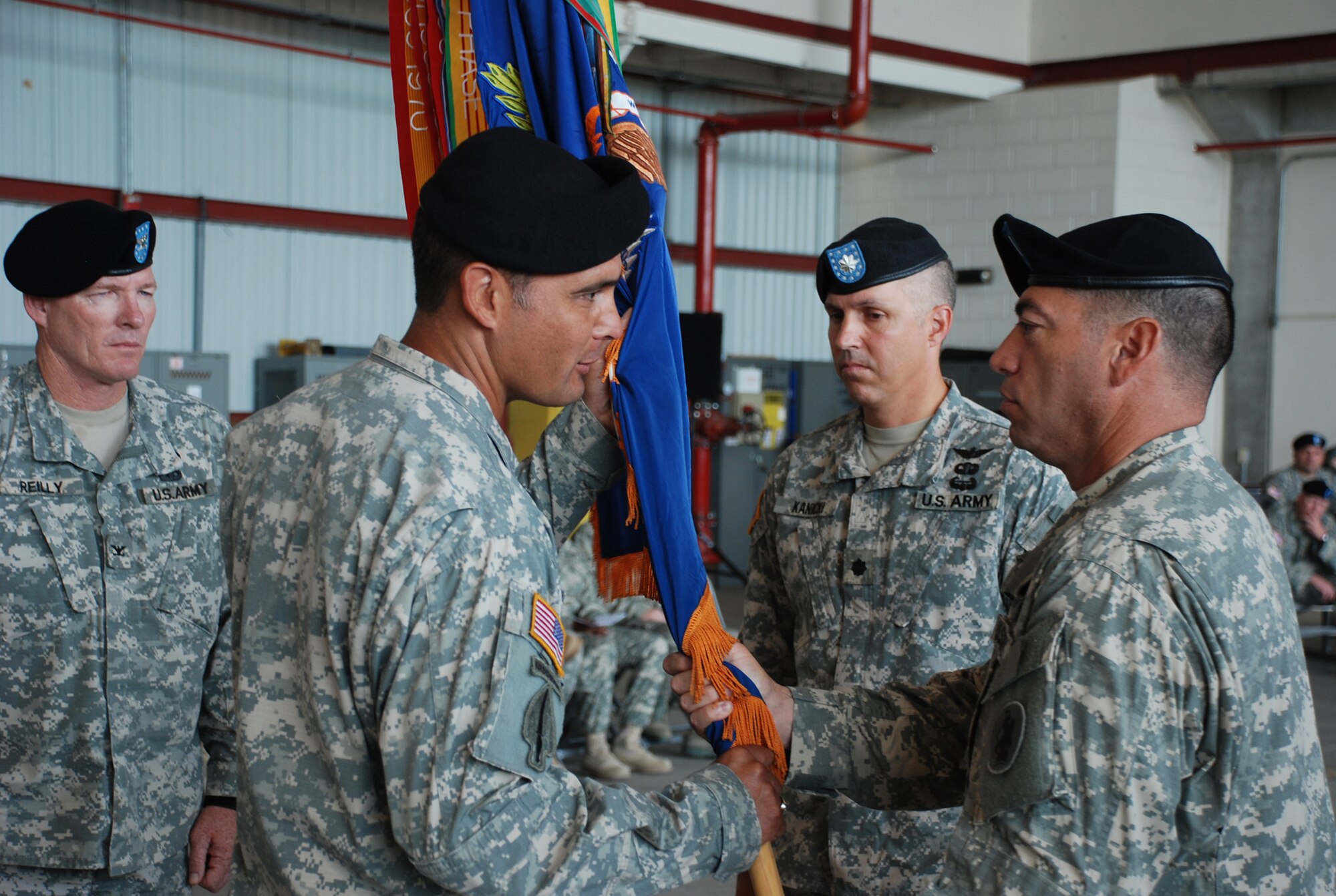 SOTO CANO AIR BASE, Republic of Honduras -- Lt. Col. Salome Herrera Jr. takes the guidon from Command Sgt. Maj. Lucio DeAnada during a change of command ceremony for the 1st Battalion, 228th Aviation Regiment here June 24. As is tradition, Colonel Herrera then passed the colors to Col. Gregory Reilly, the Joint Task Force-Bravo commander, who in turn passed the colors to the unit's new commander, Lt. Col. James Kanicki. This change of command tradition dates back to the 17th century. (U.S. Air Force photo/Tech. Sgt. Benjamin Rojek)