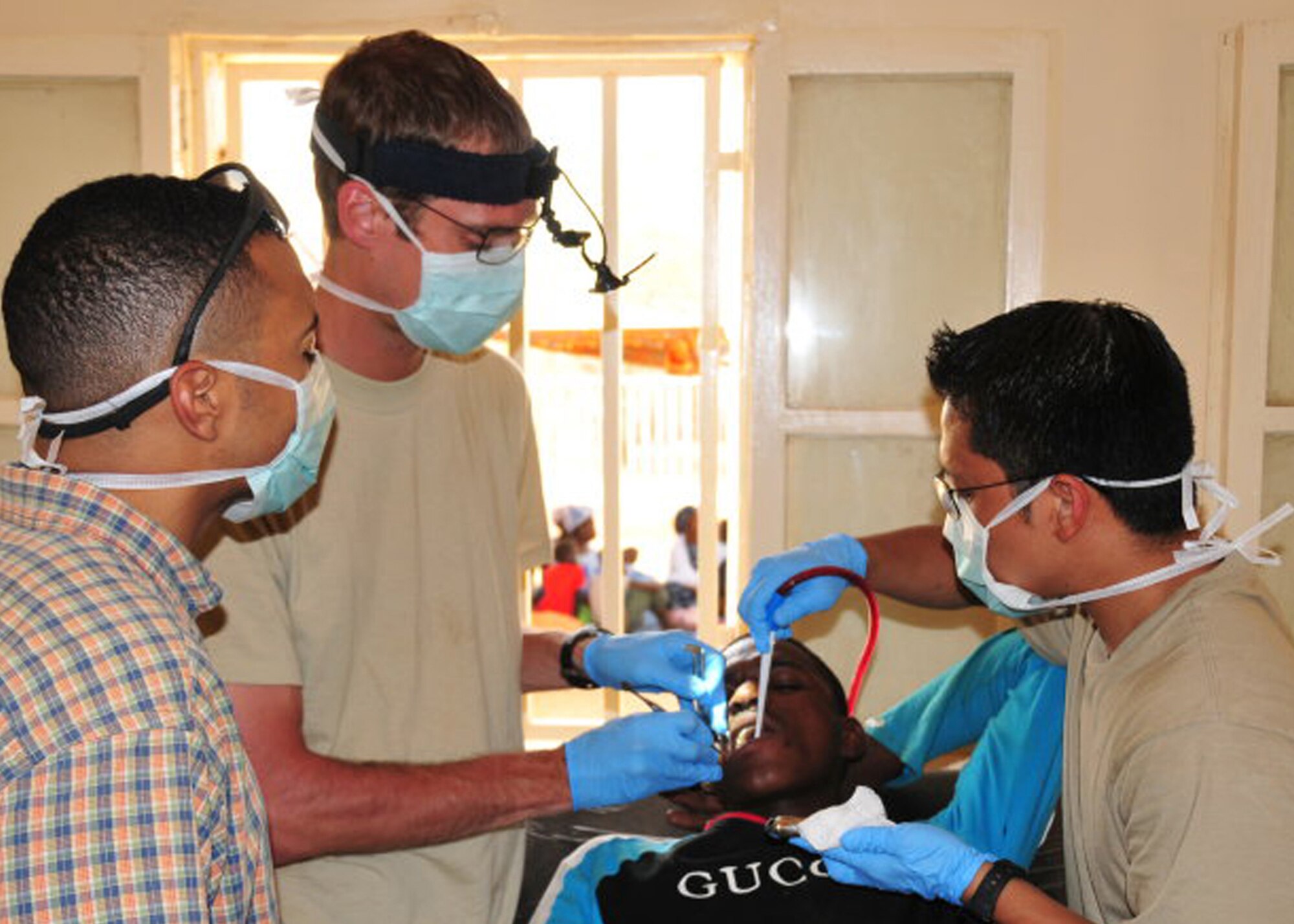 Capt. (Dr.) Ben Britten and Staff Sgt. Marc Bustria perform a dental procedure on a patient in Burkina Faso. The two Airman are assigned to the 27th Special Operations Aerospace Medicine Squadron at Cannon Air Force Base, N.M., and spent a month in Africa in a first-ever Air Force Special Operations Command medical mission support of Operation Flintlock. (Courtesy photo)