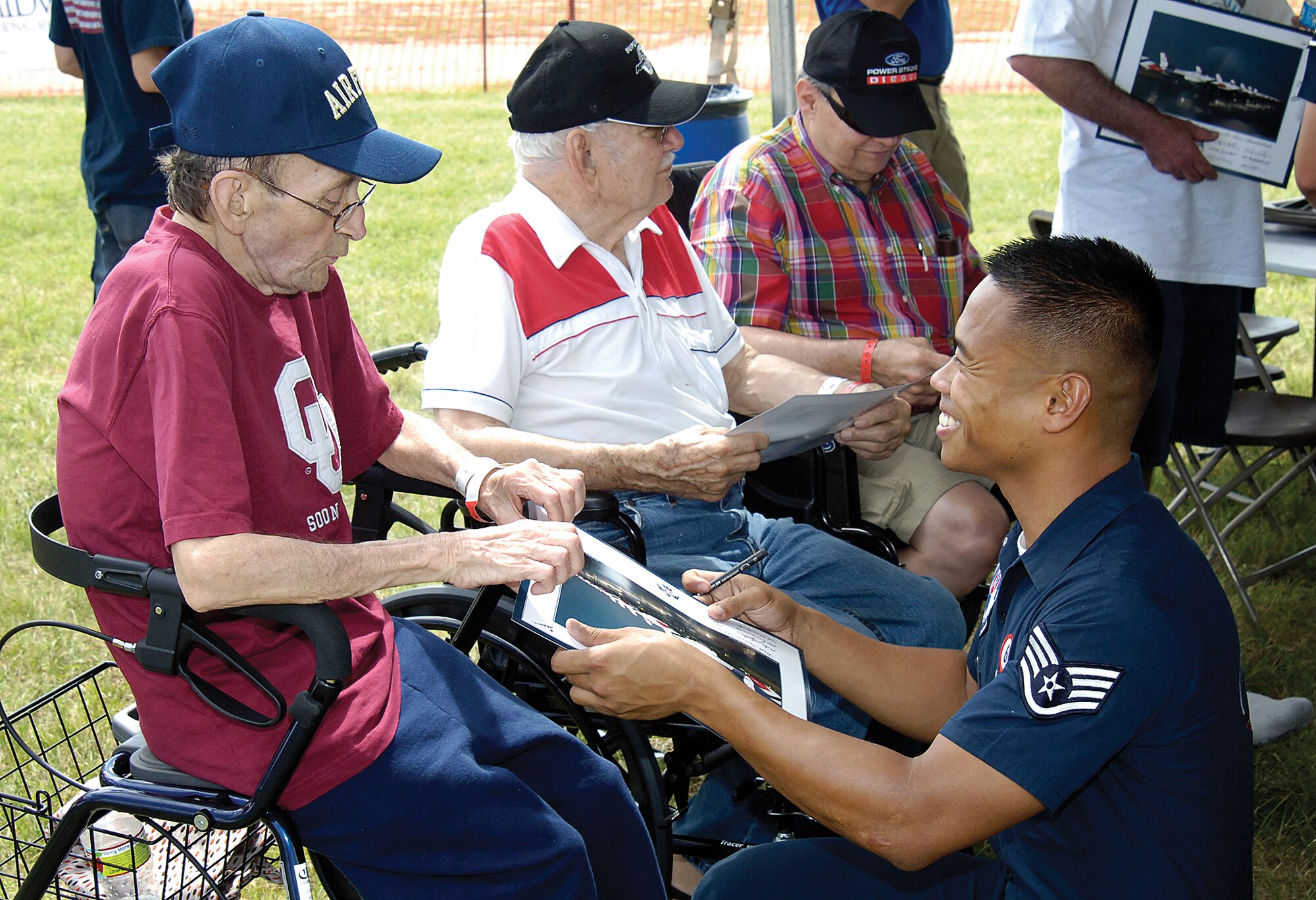 Members of the Air Force Thunderbirds demonstration team met with a group of veterans from the Oklahoma City Veterans Administration Hospital during a pre-show event June 18. Here, Staff Sgt. Joe Delos Santos, assistant No. 6 crew chief, signs a picture for Air Force veteran Ben Ealey. (Air Force photo by Margo Wright)