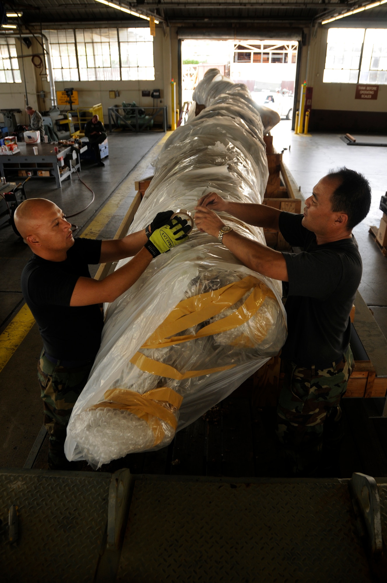 Airman 1st Class Rodolfo Fabro and Master Sgt. Daryl Oshiro, both assigned to 154th Wing Hawaii Air National Guard, strap in the 40-foot mast at Pearl Harbor. (Navy photo by SW2 Mark Logico)