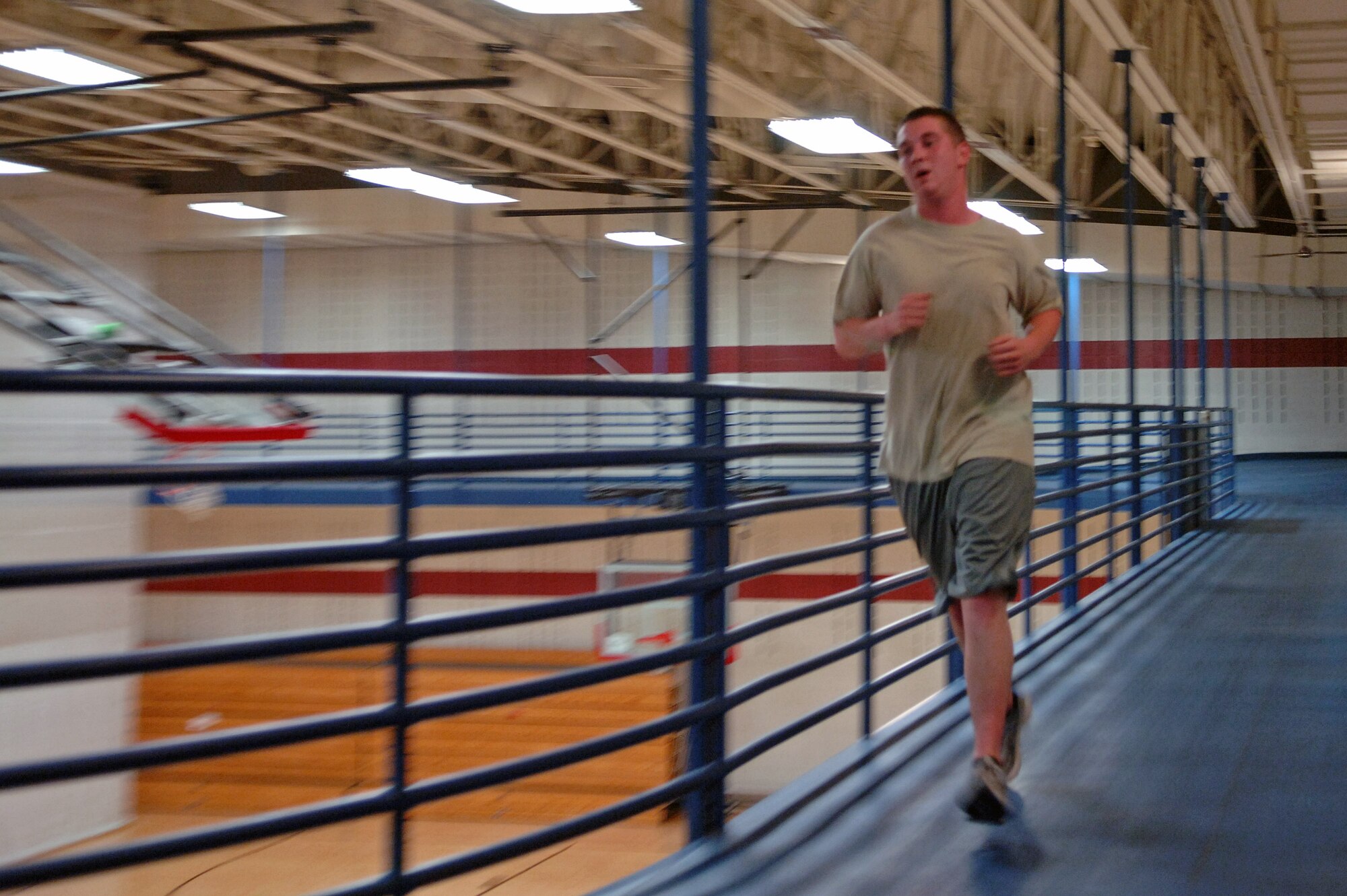 ELLSWORTH AIR FORCE BASE, S.D. – Airman 1st Class Jody Harding, 28th Maintenance Squadron trailer maintenance specialist, runs around the indoor track at the Bellamy Fitness Center during a mid-day workout, June 22. With the July 1 implementation of the new Air Force physical training standards less than a week away, Airmen on base have begun training to meet and exceed the requirements. (U.S. Air Force photo / Airman 1st Class Jarad A. Denton)