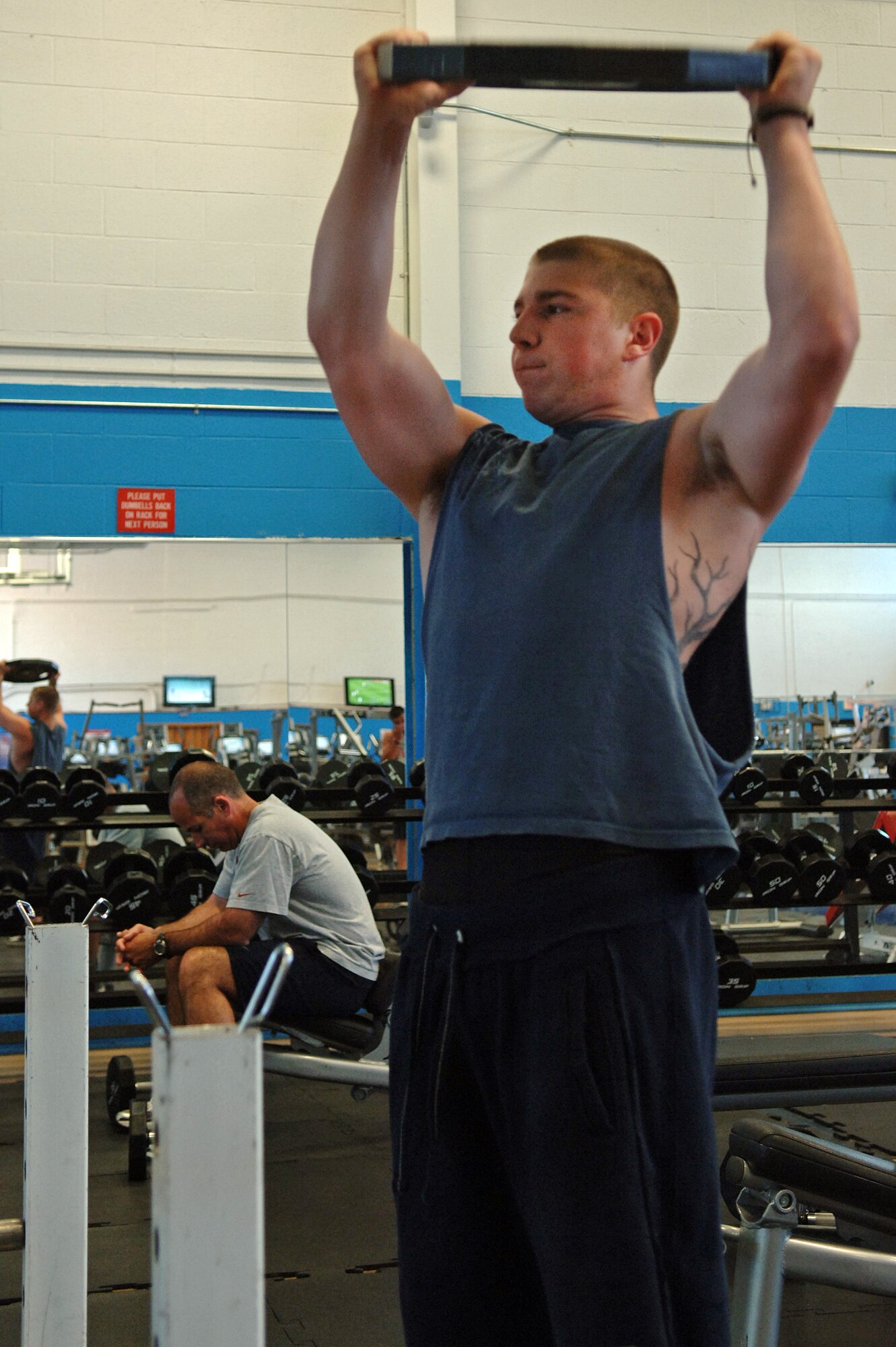 ELLSWORTH AIR FORCE BASE, S.D. – Airman 1st Class Luke Longeretta, 28th Logistics Readiness Squadron aircraft parts store specialist, lifts a 45-pound plate over his head during his workout at the Bellamy Fitness Center, June 22. Airman Longeretta works out to develop a fitness lifestyle, rather than pass a physical training test. (U.S. Air Force photo/ Airman 1st Class Jarad A. Denton)