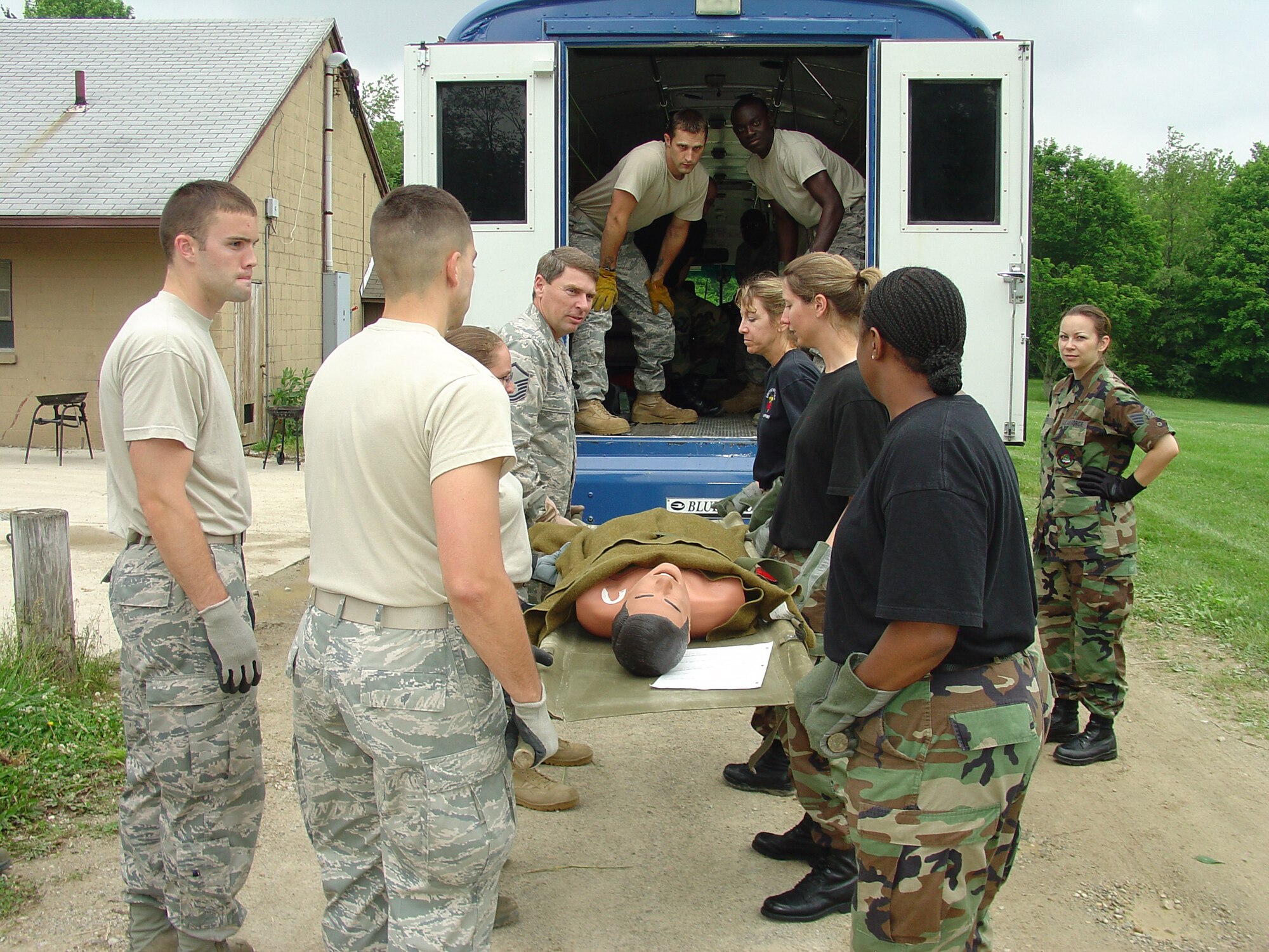 WRIGHT-PATTERSON AIR FORCE BASE, Ohio – Reservists from the 445th Aeromedical Staging Squadron simulate how to unload patients from an ambus during a field training exercise at Camp Birch in Yellow Springs, Ohio, June 5.  The field training exercise gave the reservists a chance to work as a group to polish their skills they would use in deployed locations. (U.S. Air Force photo/Maj. Mary Reed)