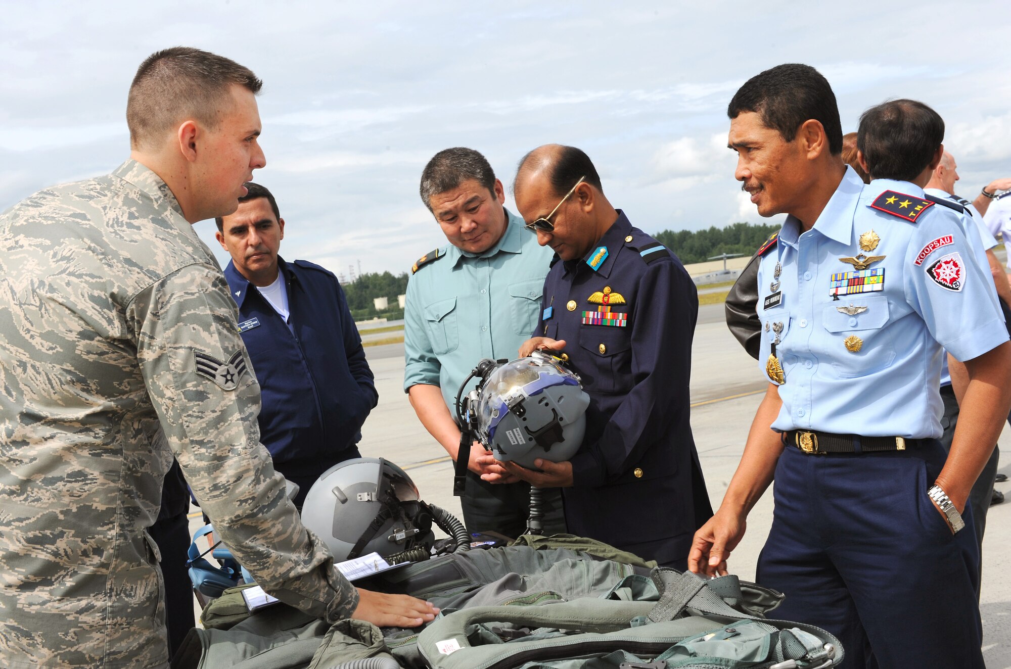 Senior Airman Shawn McCoy explains the different types of flight gear used in aircraft during the 2010 Executive Observer Program June 18, 2010, at Joint Base Elmendorf-Richardson, Alaska. Sixteen general officers from 16 different countries joined Pacific Air Forces leaders in their premier multinational large force employment exercise while building partnerships with senior airpower leaders from the global community. Airman McCoy is an aircrew flight equipment specialist with the 525th Fighter Squadron here. (U.S. Air Force photo/Senior Airman Cynthia Spalding)