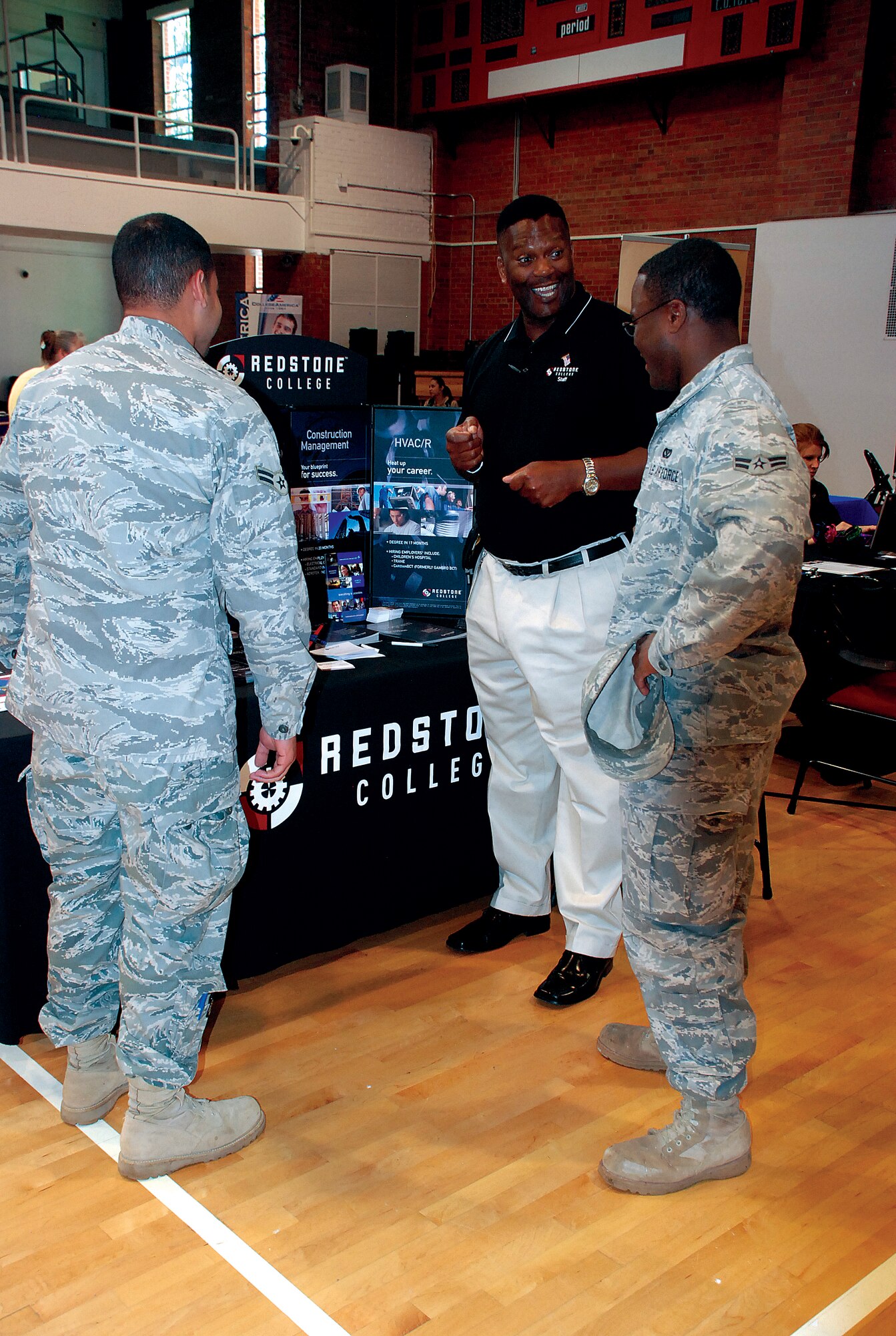Members of the Mighty Ninety speak to a representative from Redstone College, Broomfield, Colo., during the education fair June 16 in the Fall Hall Community Center. Thirty-eight colleges, universities and alternative schools hosted booths at the event, which was meant to educate members and their families about degree programs available in the local area. (Photo by Airman 1st Class Jennifer Viveiros)