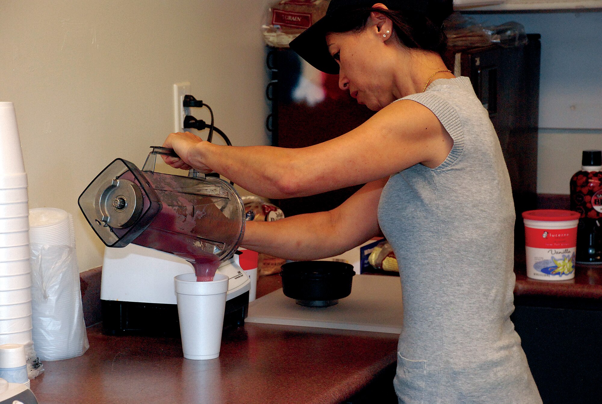 Pam Louie-Cooper makes a fruit smoothie in the “XLR8” snack bar located inside the Freedom Hall Fitness Center June 17. The snack bar has been open for about two weeks and serves healthy snacks for pre- or post-workout customers. XLR8 is open Mondays to Fridays from 9 a.m. to 6 p.m. To make phone-in orders, call 773-6171. (Photo by Staff Sgt. Chad Thompson)