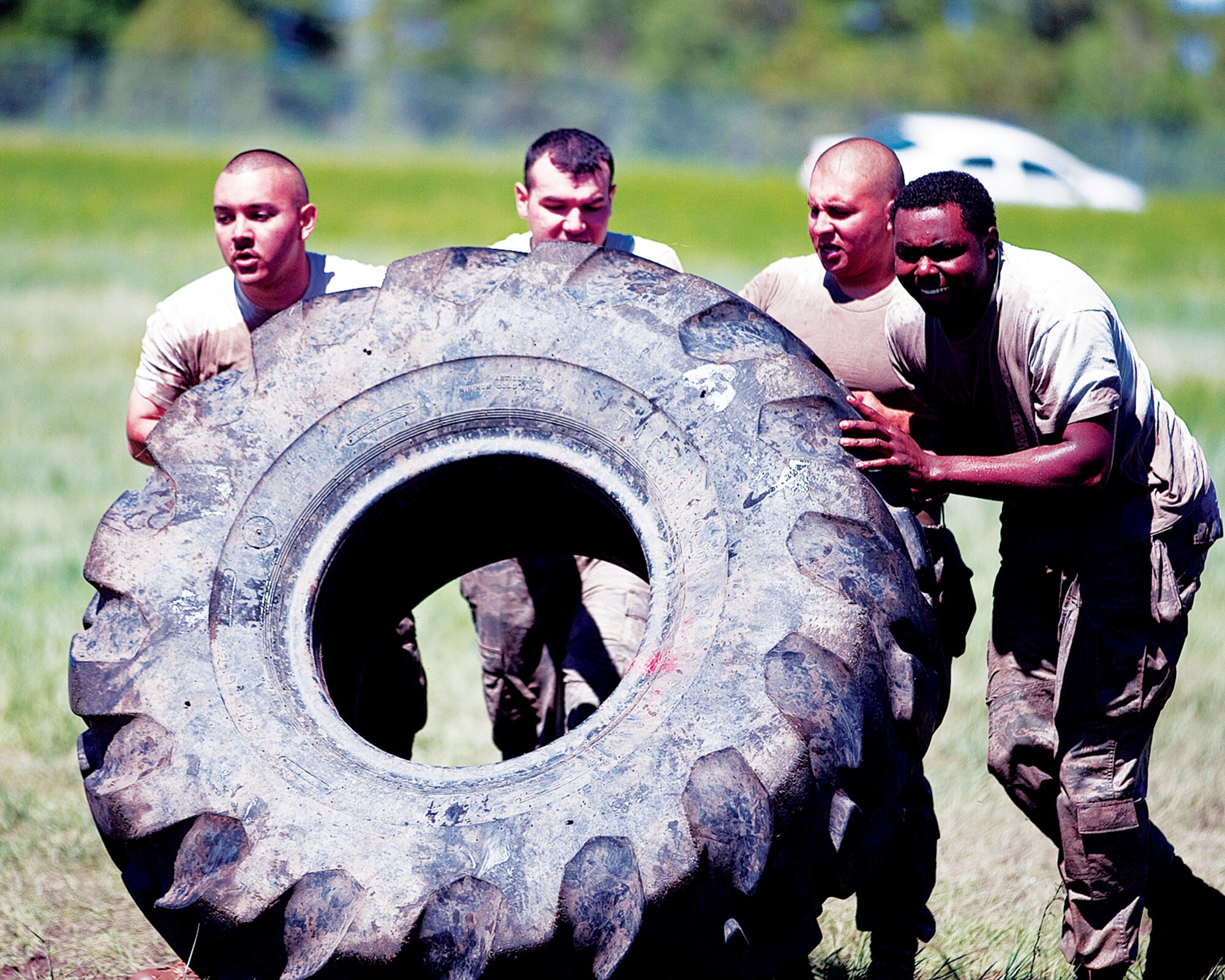 A security forces team flips a tire as part of the "Team Pain" portion of the Crow Creek Challenge. The team had to flip the tire 25 meters before moving onto the next event. (Photo by Jeff Allred)