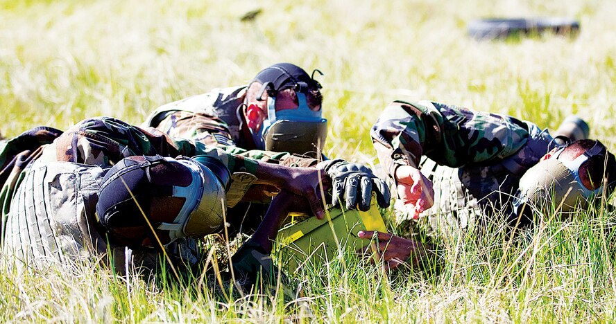 A security forces team completes the patrol orientation event during the 17th annual Crow Creek Challenge which was held near the outdoor firing range. Patrol orientation forced the individuals to rely on their other senses to locate a box in the field, because their gas masks were covered with duct tape, so they couldn't see. Once a person found the box, he had to communicate to his fellow teammates the location. In order to complete the challenge, all members had to touch the box. (Photo by Jeff Allred)